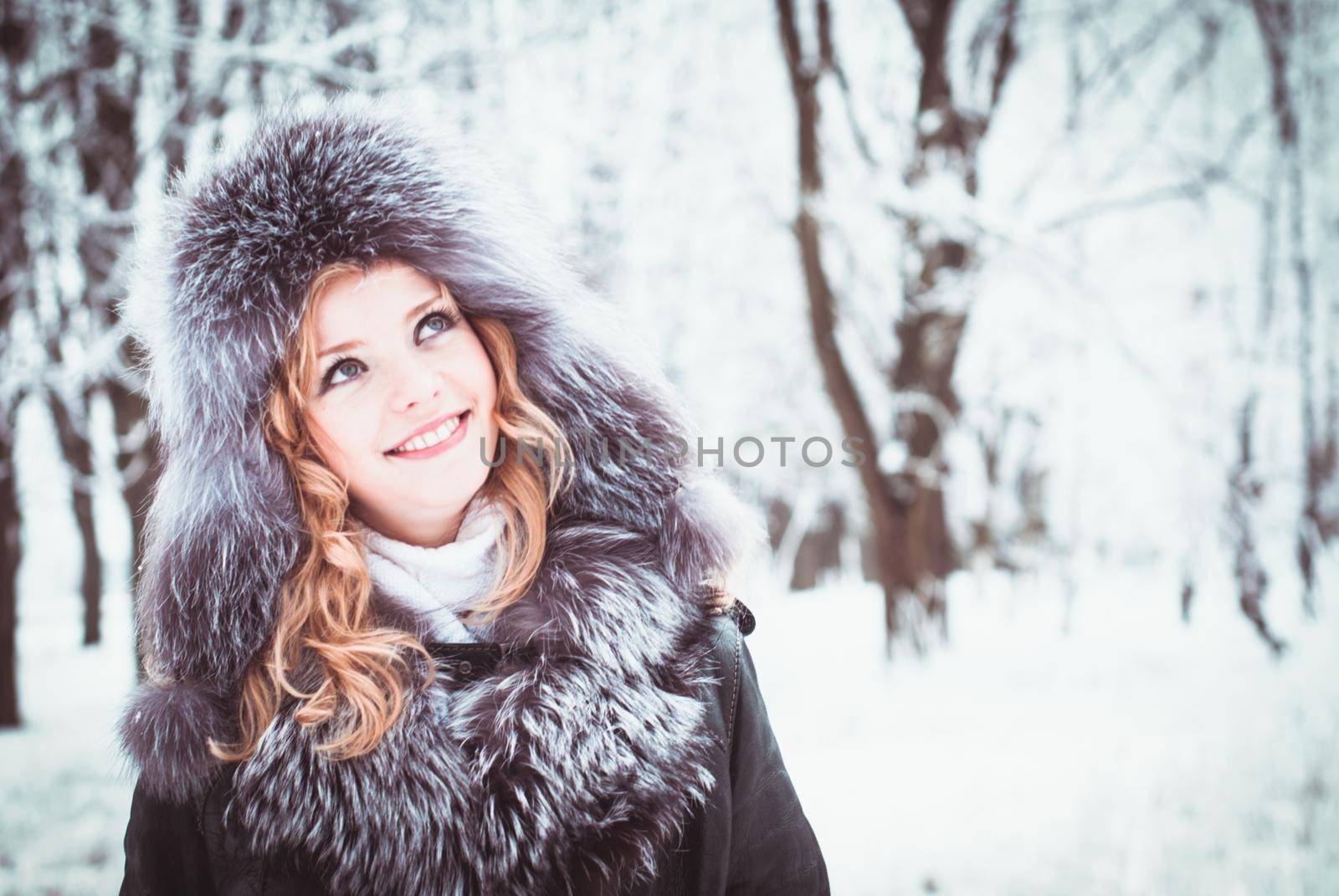 Woman is walking in park alley in winter