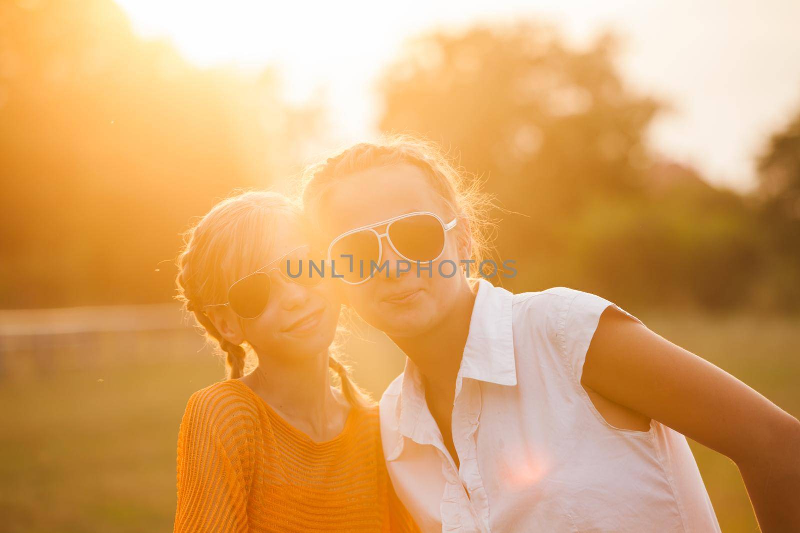 Two teenage girls have fun in the park. Two friends outdoor. Summer people in glasses