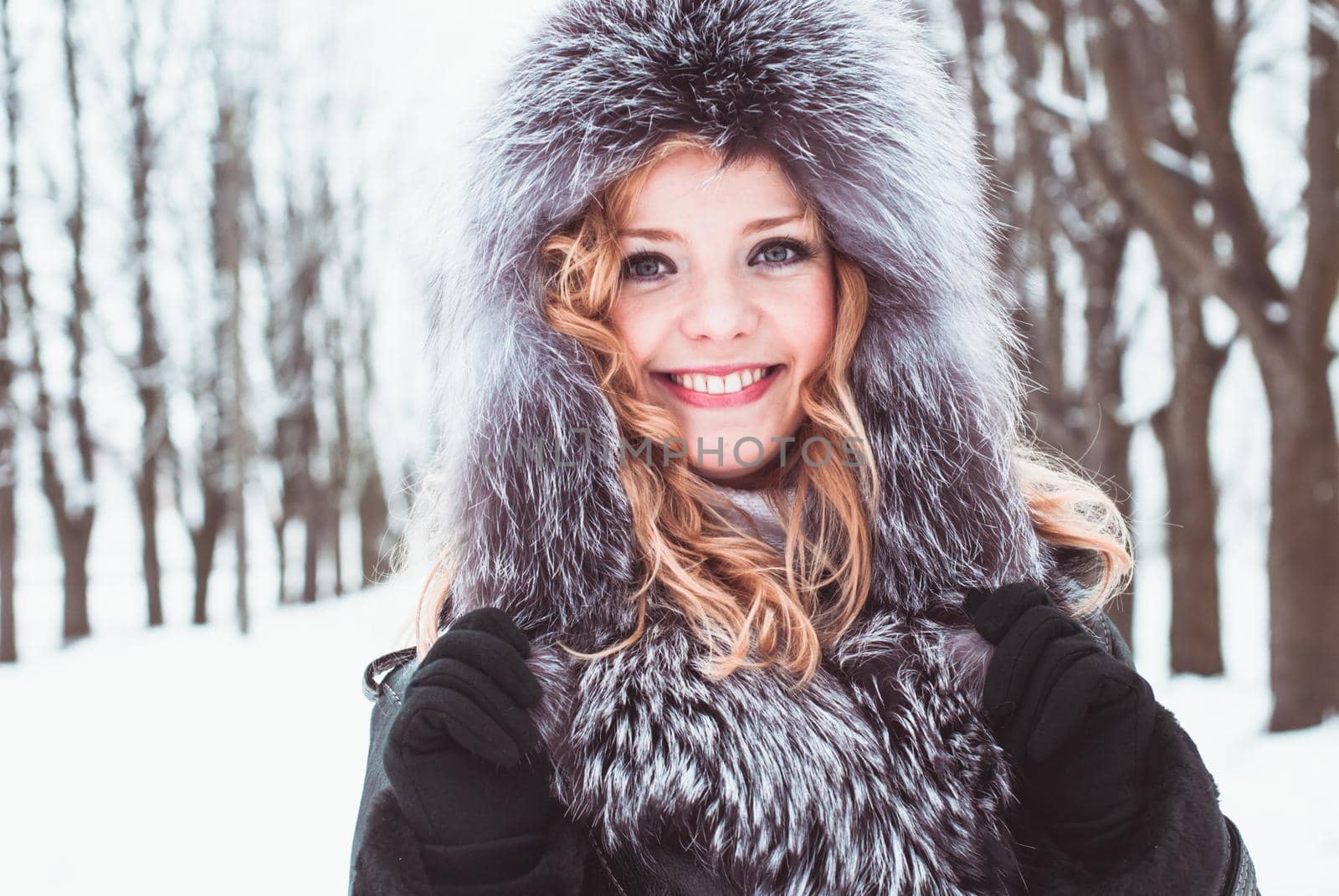 Woman is walking in park alley in winter