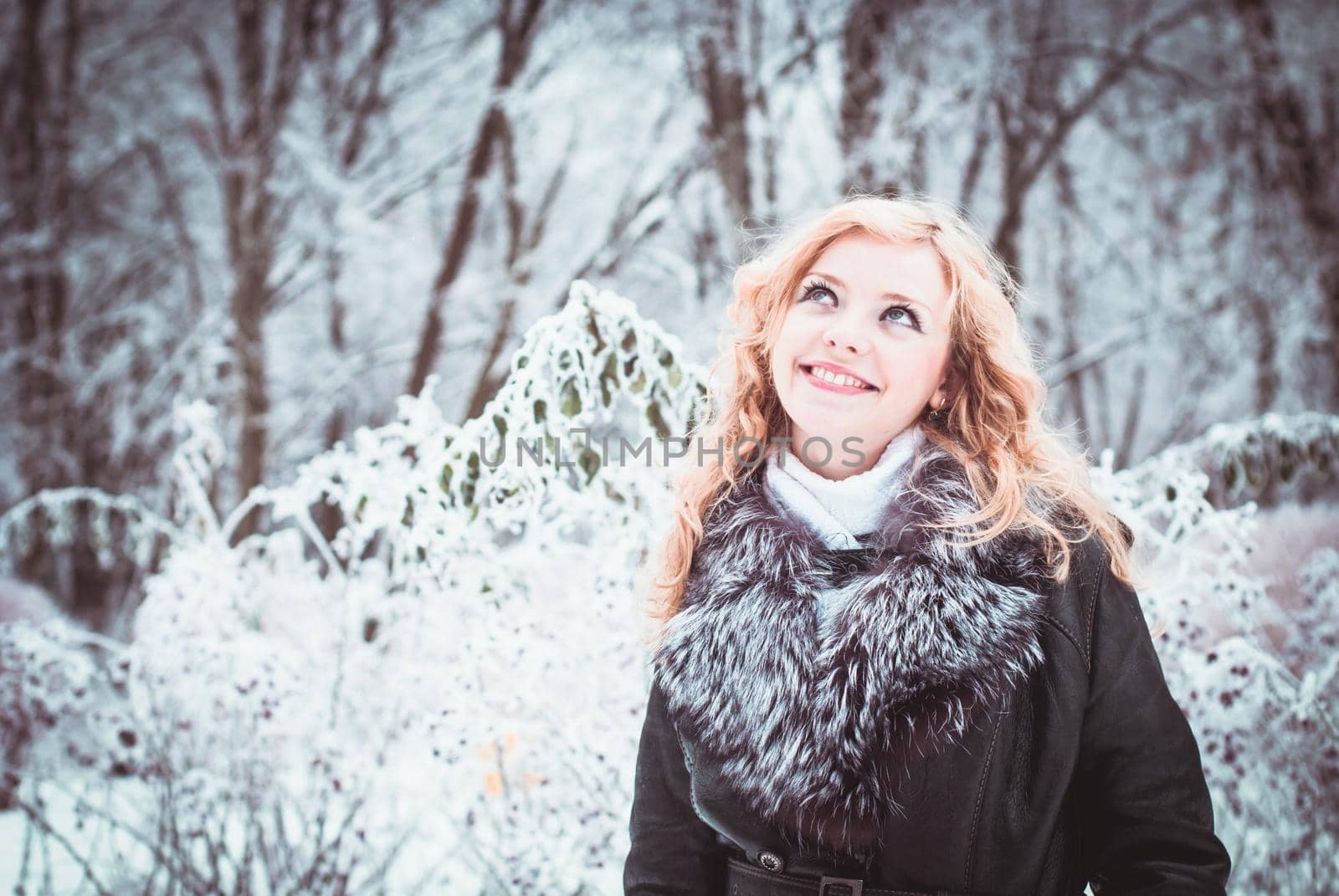 Woman is walking in park alley in winter