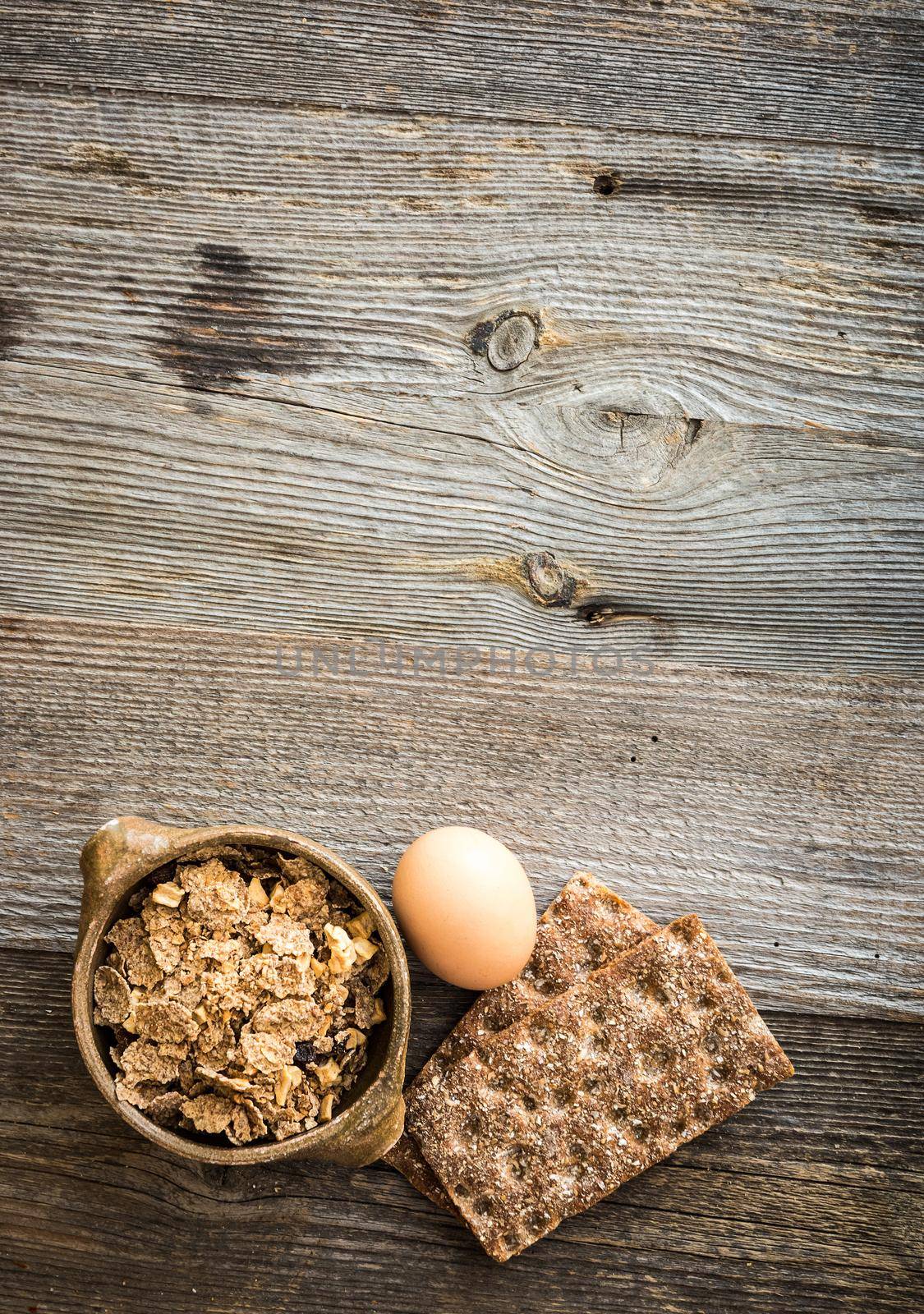 fitness breakfast with egg, flakes and bread on wooden background