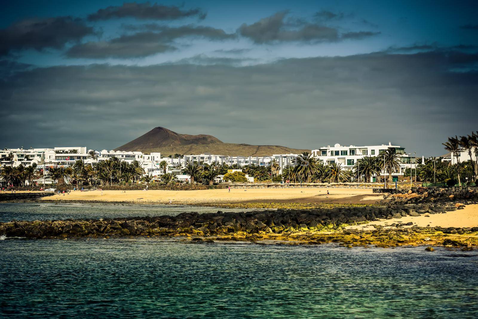 desert Lanzarote coast with a township on the background, Canary Islands, Spain