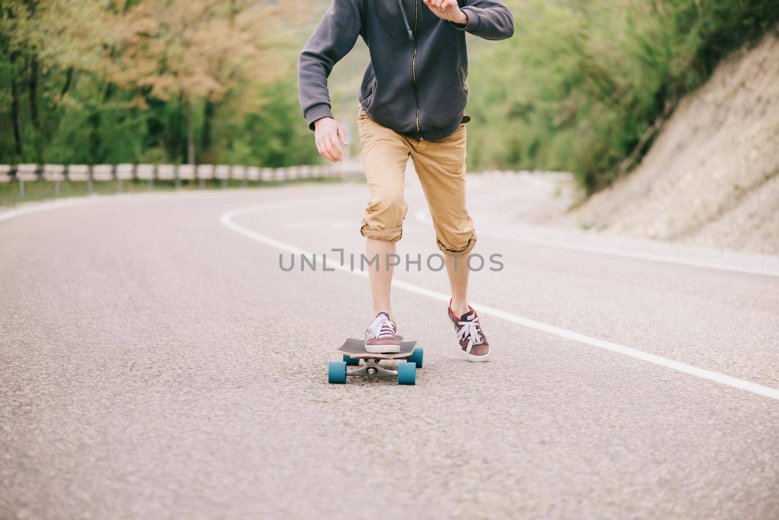 Guy riding on longboard asphalt road. by alexAleksei