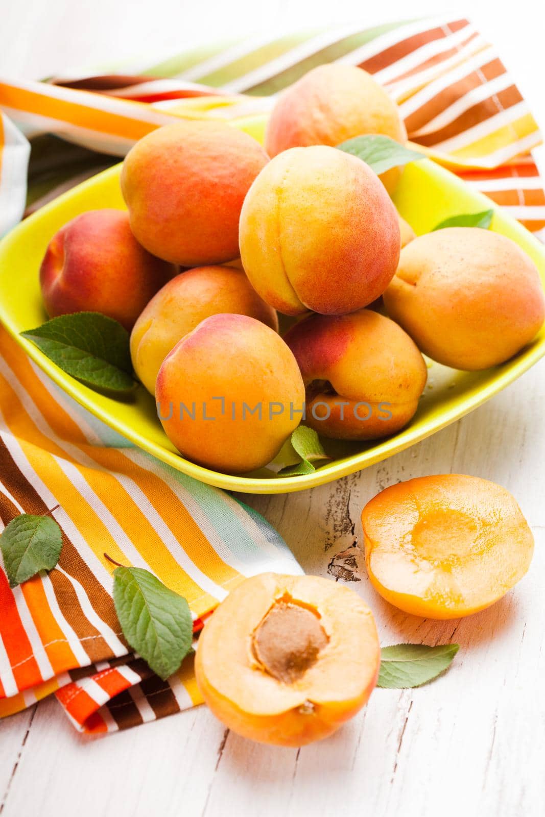 Fleshy apricots in the bowl on the table