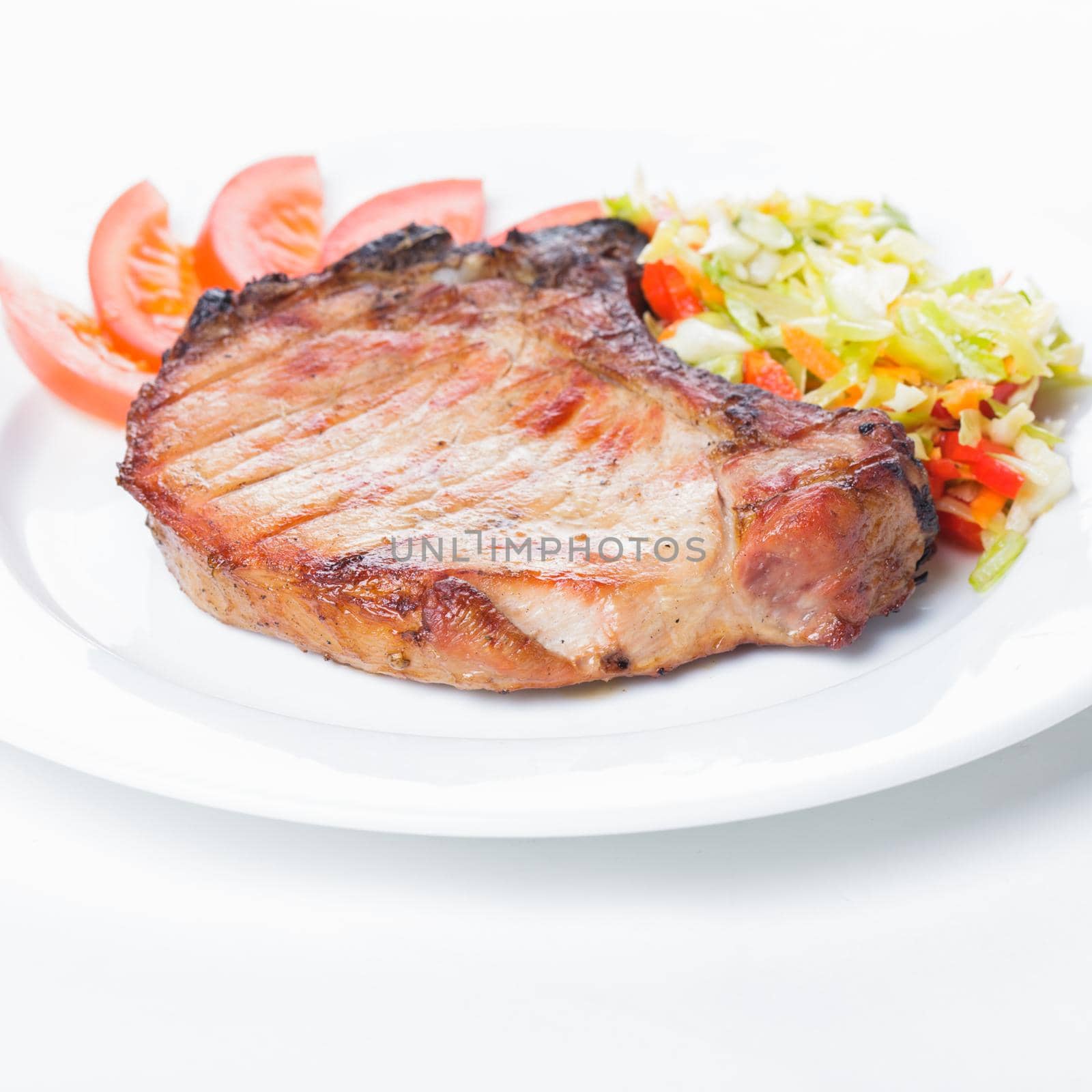Grilled meat with spices on a white plate
