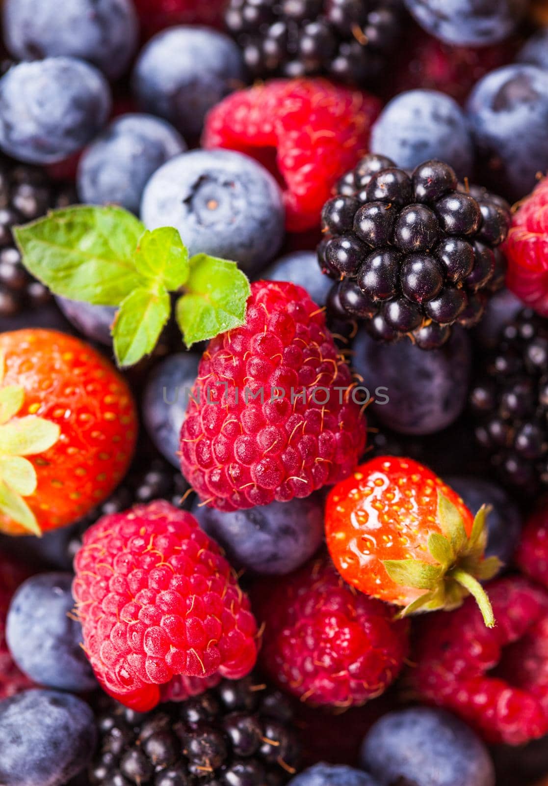 Summer wild berries as a background - raspberry, strawberry, blackberry and blueberry