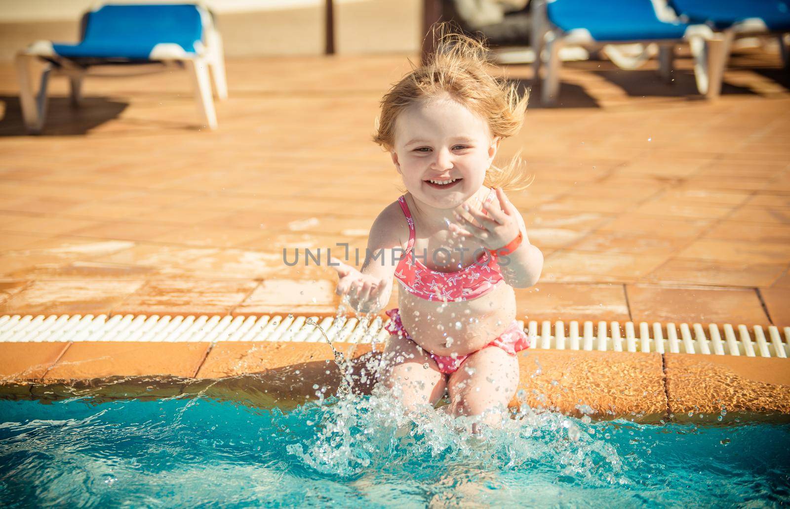 happy little girl playing in the pool