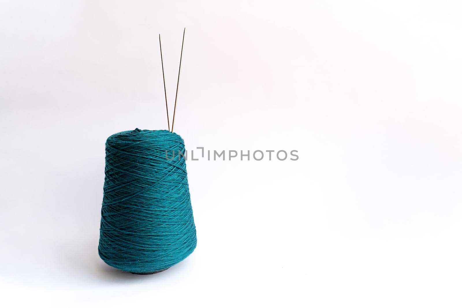 Skein of thread and two needles are on white background by uveita