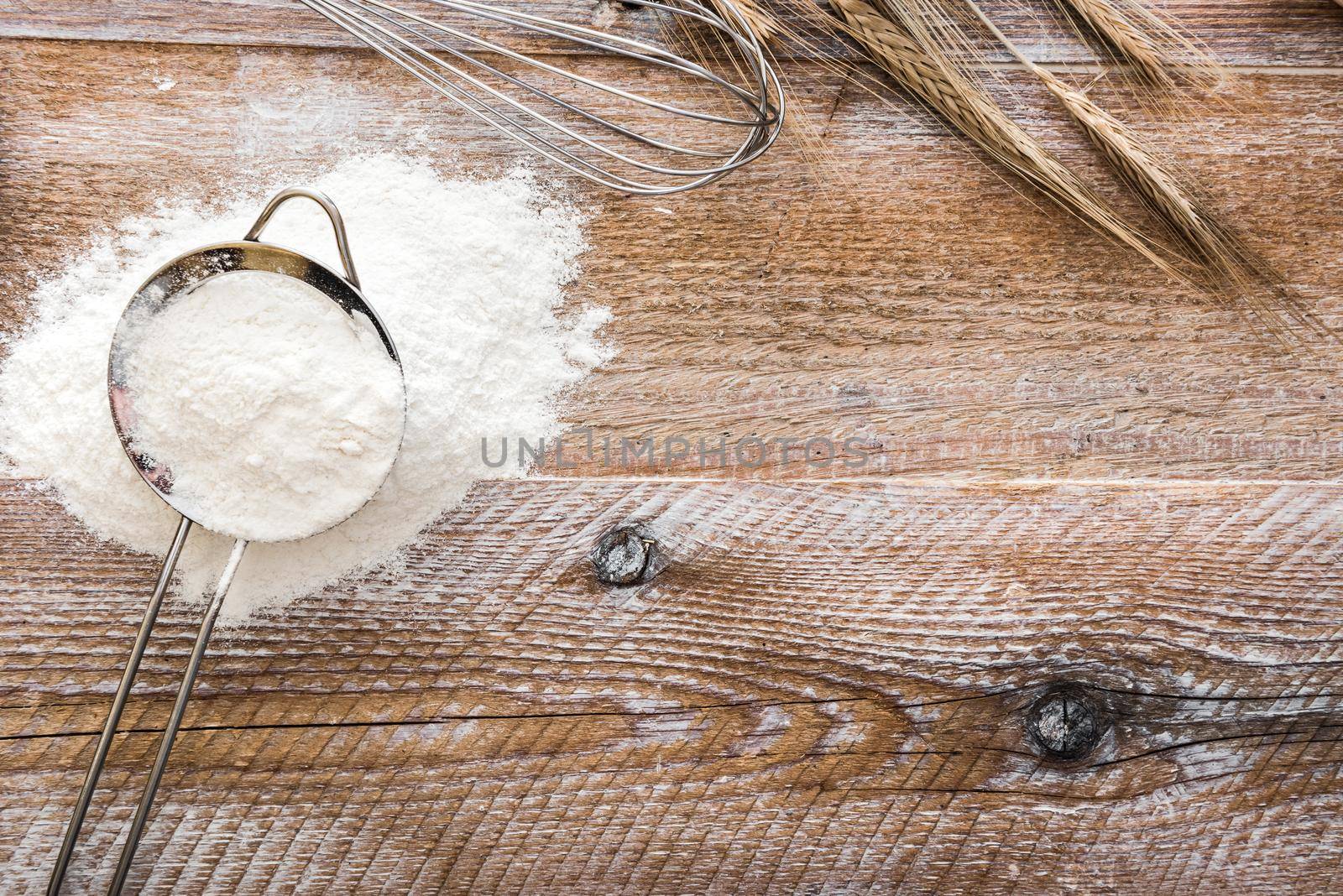 Sieve with flour on wooden board