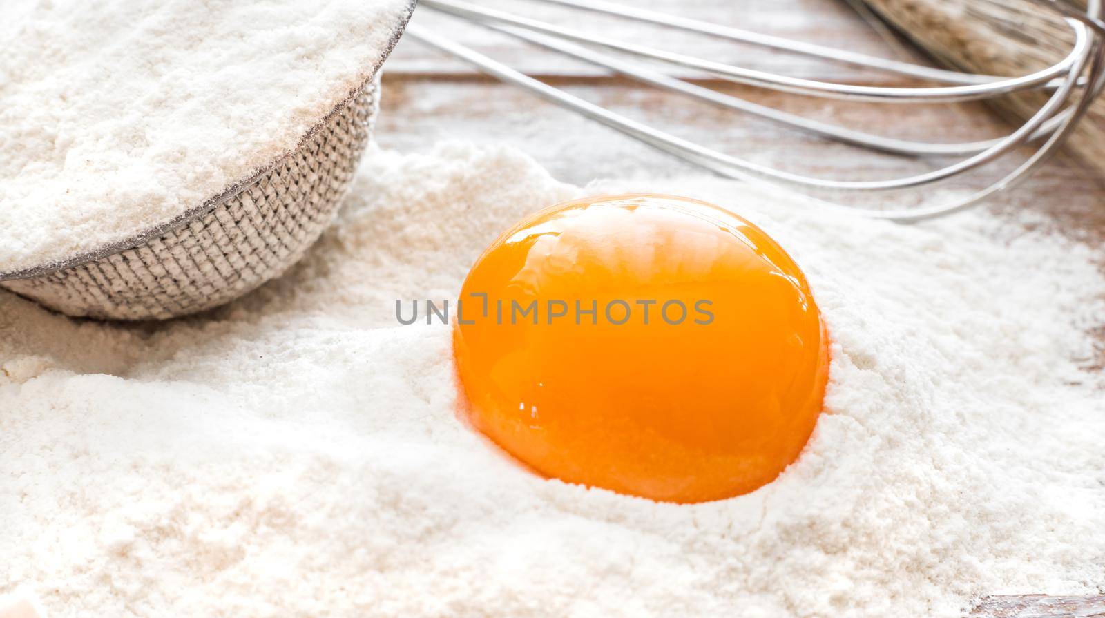 Egg yolk in flour on a wooden board