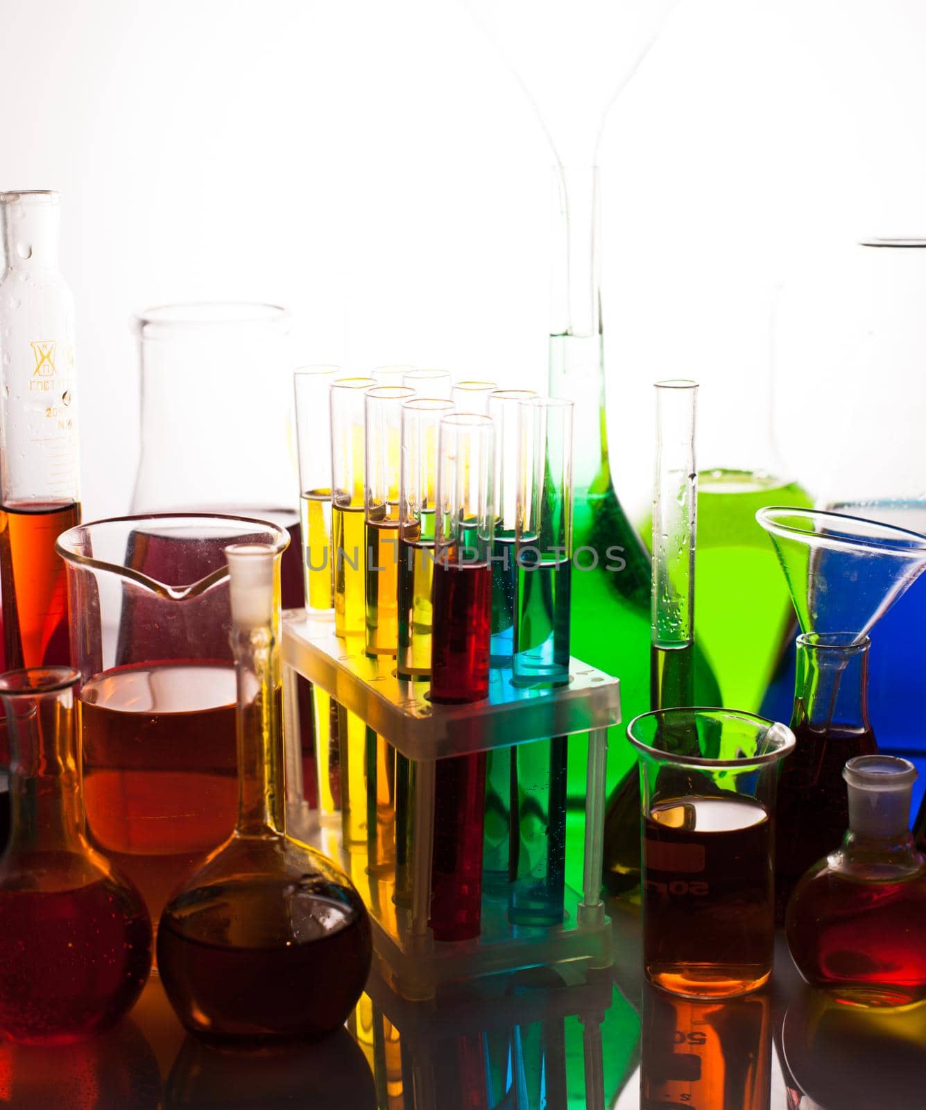 Laboratory glass with rainbow color liquids, chemistry still life