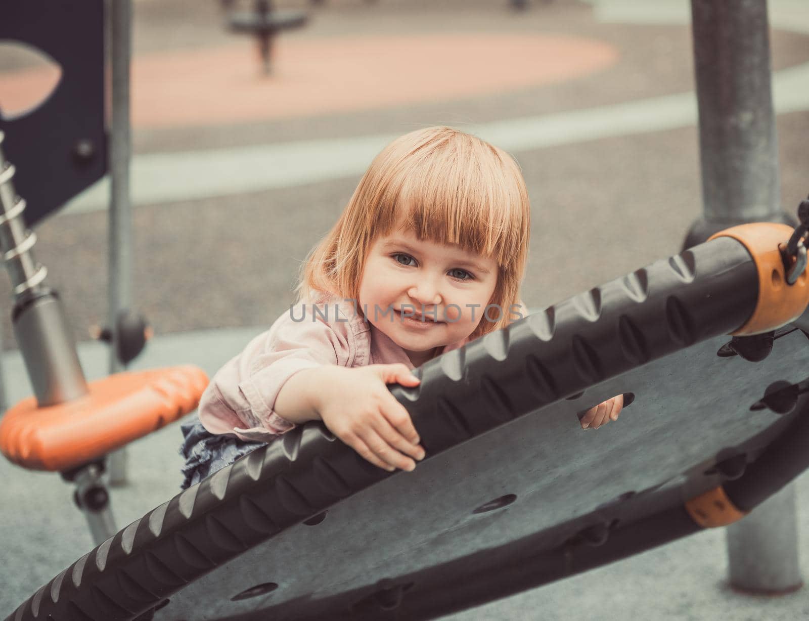 cute little girl on a swing on playground