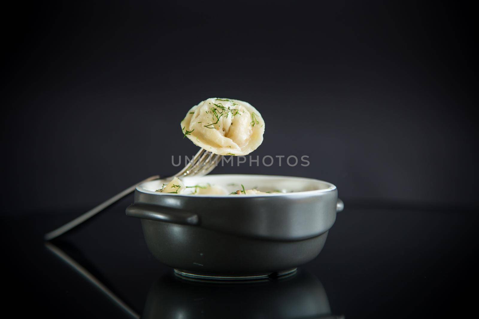 boiled dumplings with meat filling in a bowl on the table