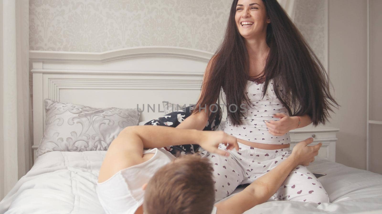 Happy family couple spending time in bed, laughing and cuddling, people's attitudes, close up