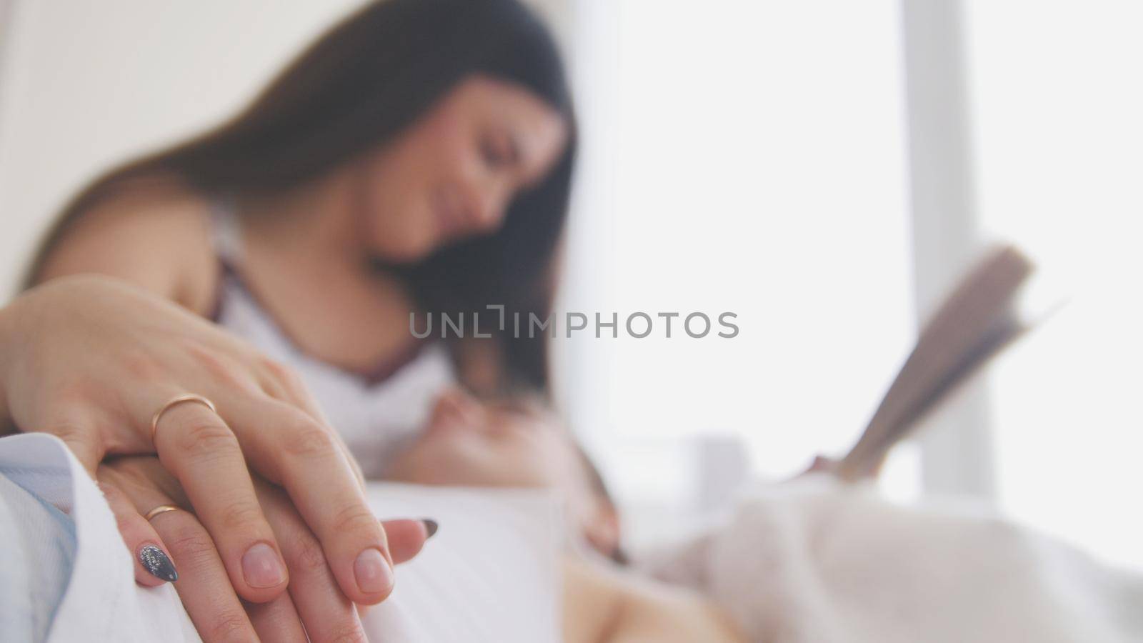 Happy young attractive couple are together on the couch, the girl reads a book, close up