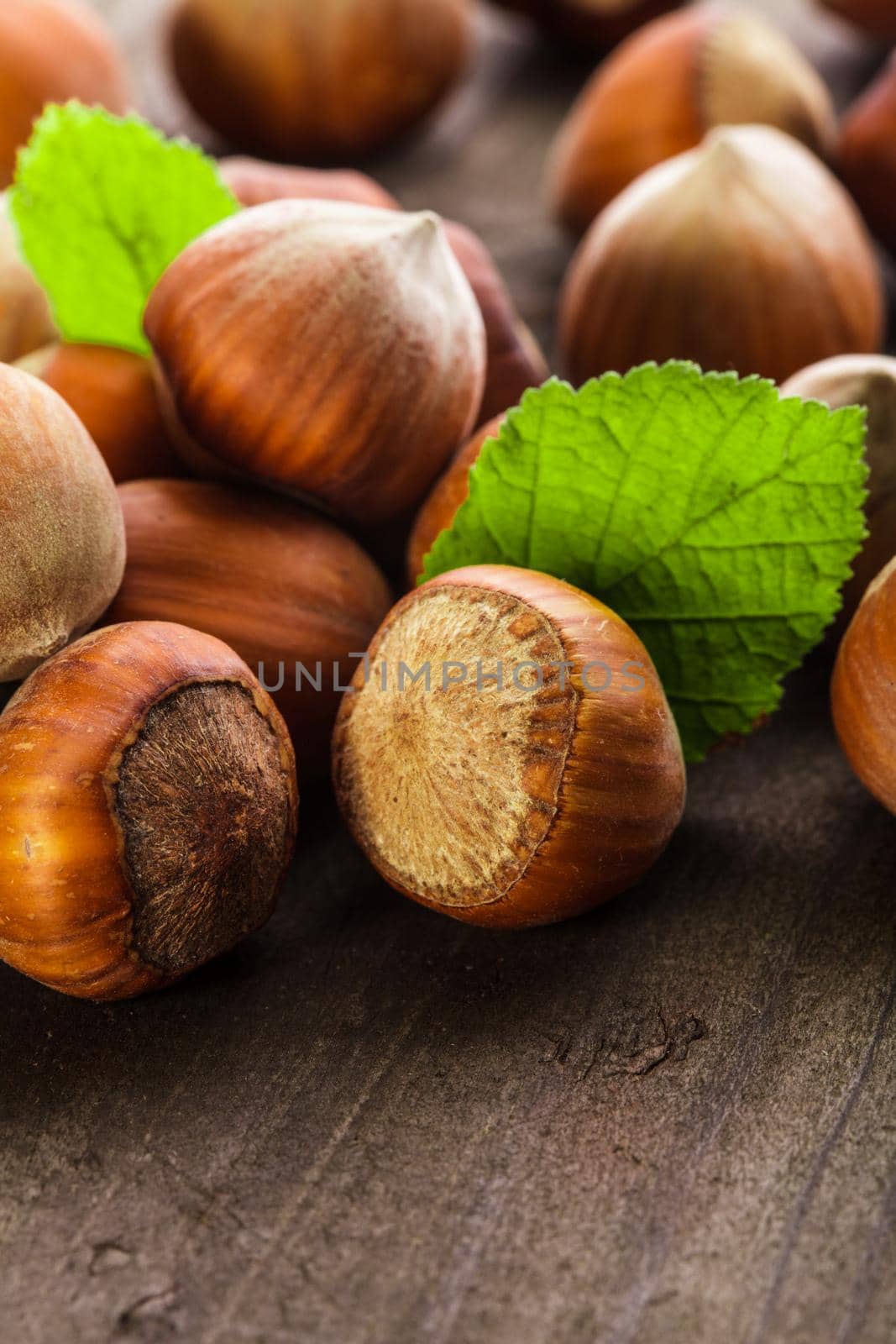 Hazelnuts with shell and green leaf on the wooden table