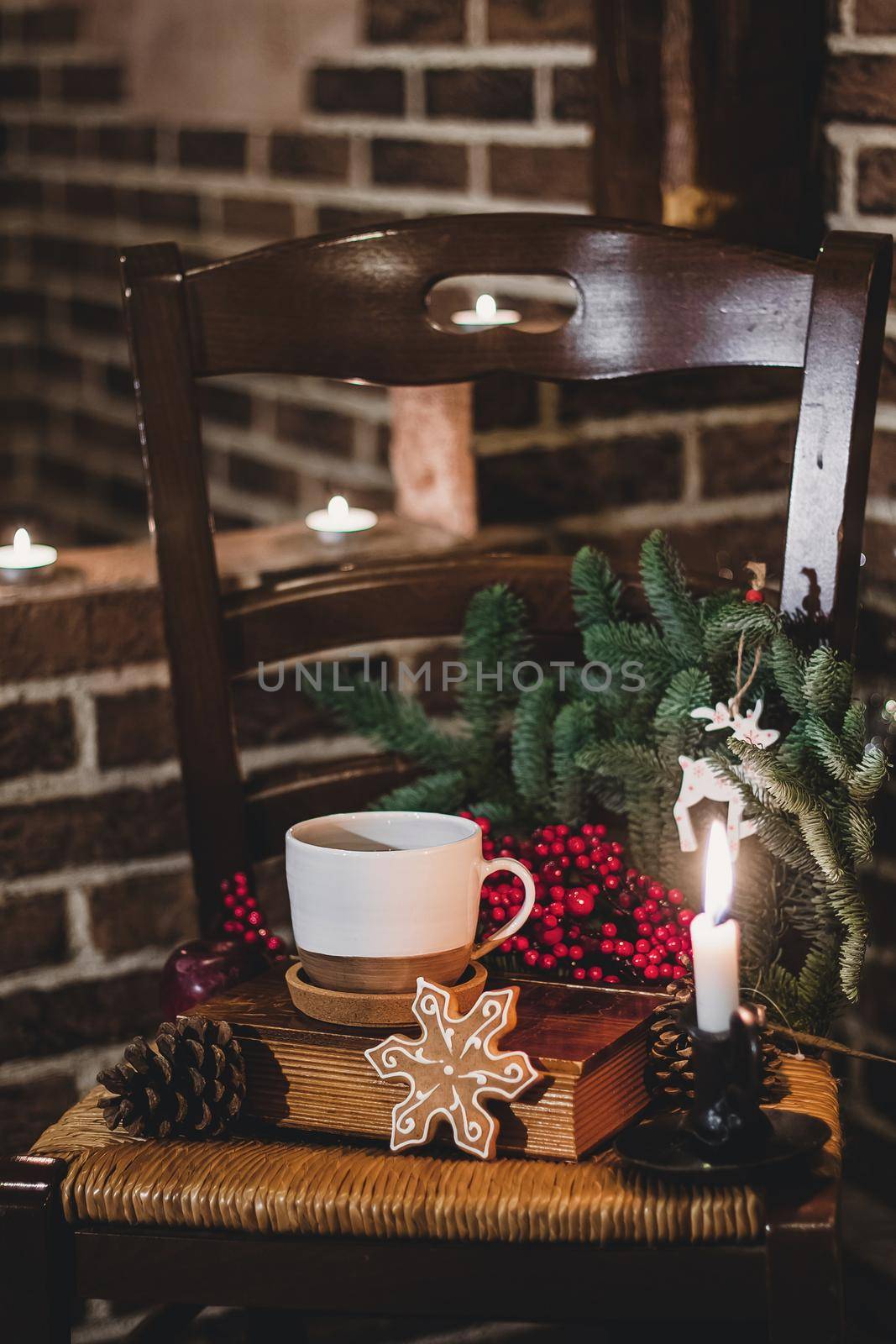 Christmas hot chocolate with mini marshmellows in an old ceramic mug with candles on a wooden background.