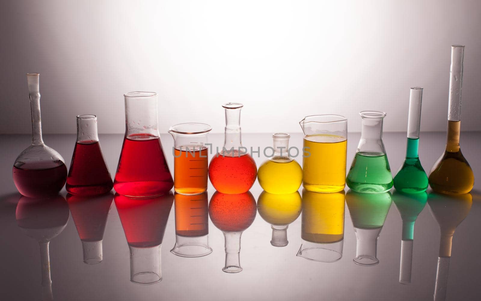 Laboratory glass with rainbow color liquids, chemistry still life