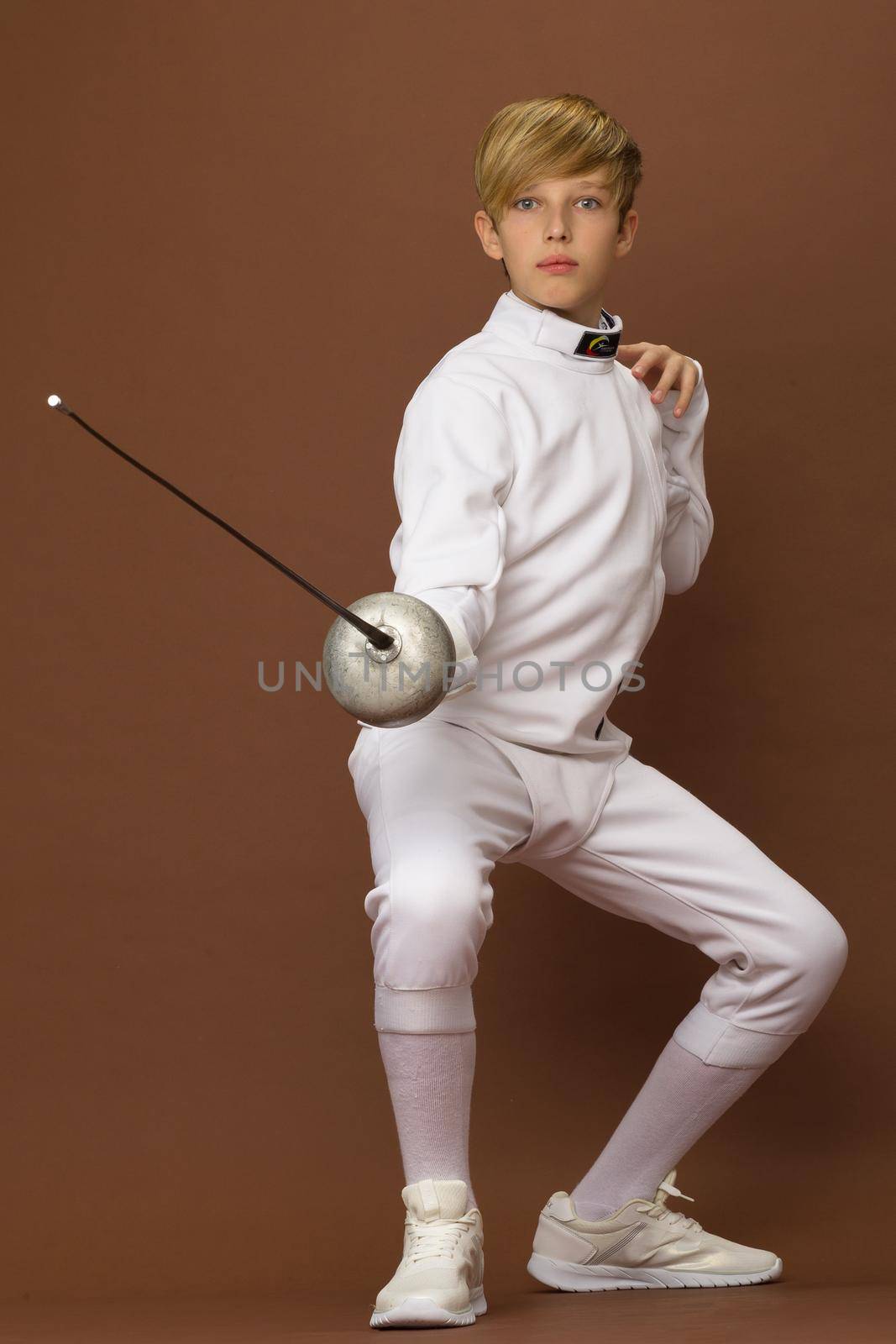 Boy fencer standing in attacking pose by kolesnikov_studio