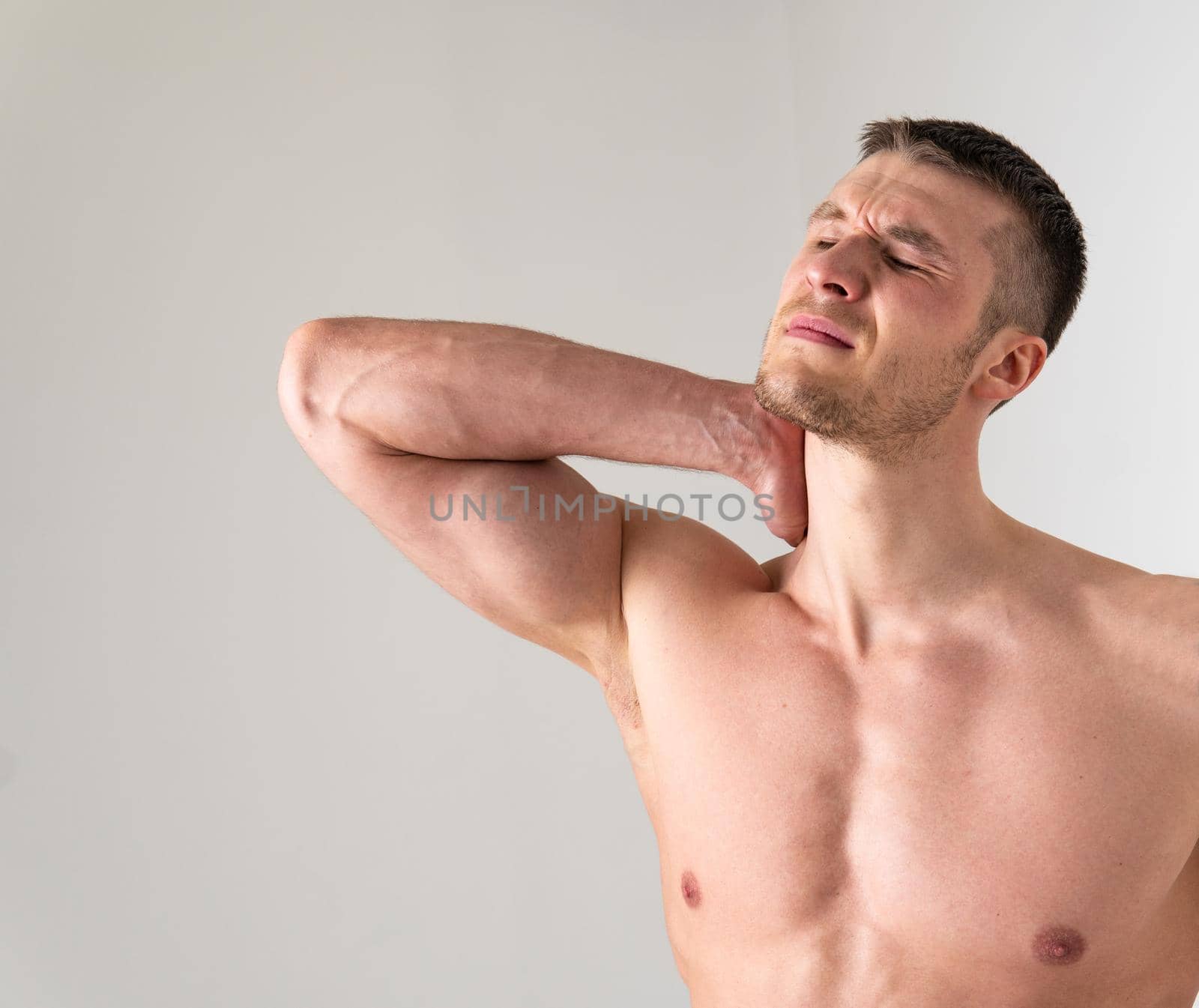 The muscles of the neck in a man on a white background are hurt ache hurt muscle, cramp spine white young medicine, illness holding. neck disease suffer attractive
