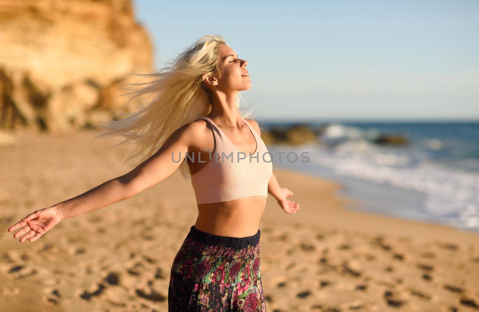 Woman enjoying the sunset on a beautiful beach by javiindy