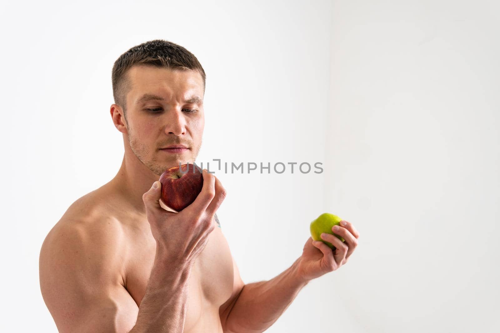 Man holds apples in fitness white background isolated isolated body, sexy young muscle background, nude. Guy hold wellness chest by 89167702191
