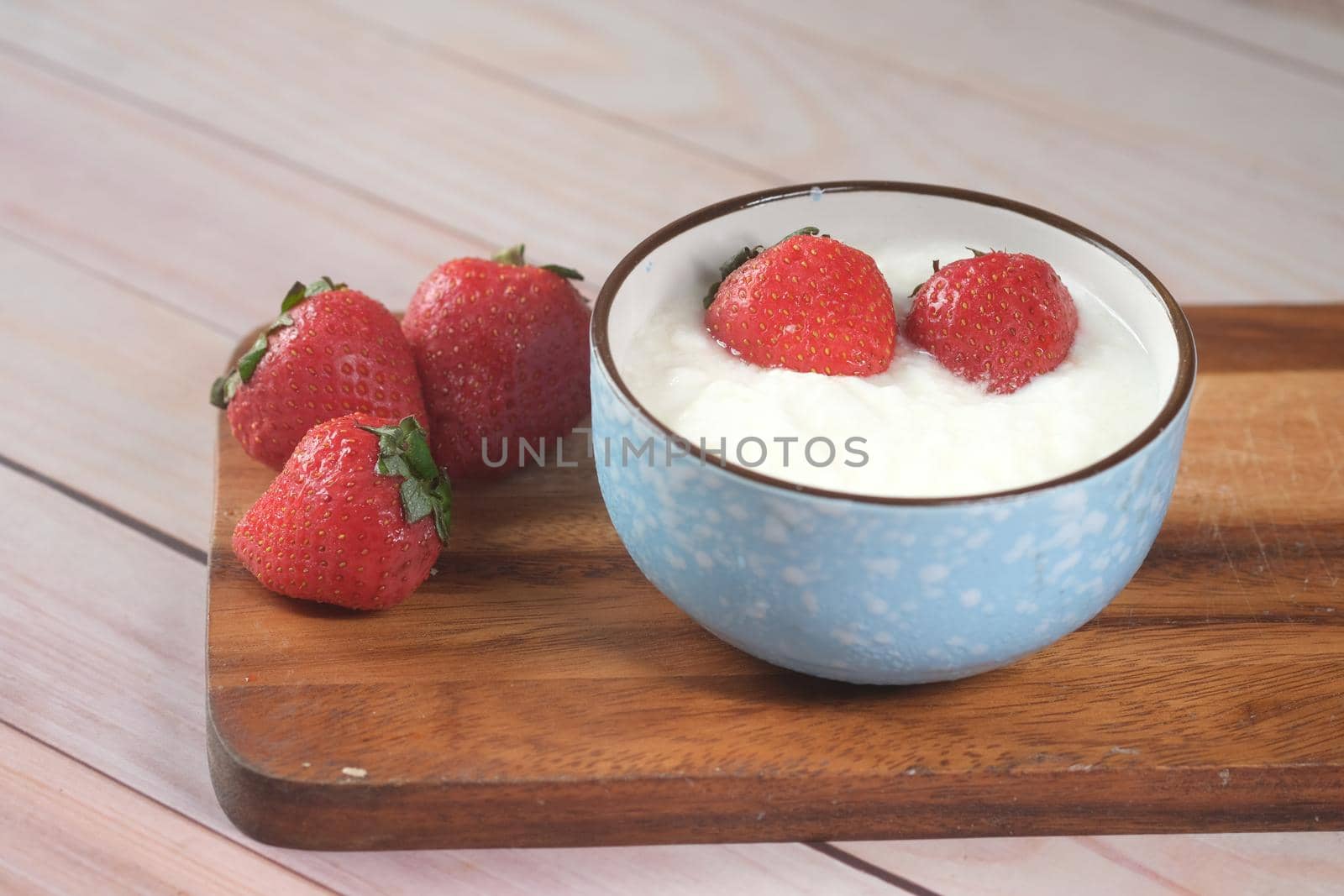 fresh strawberry and yogurt in a bowl on table .