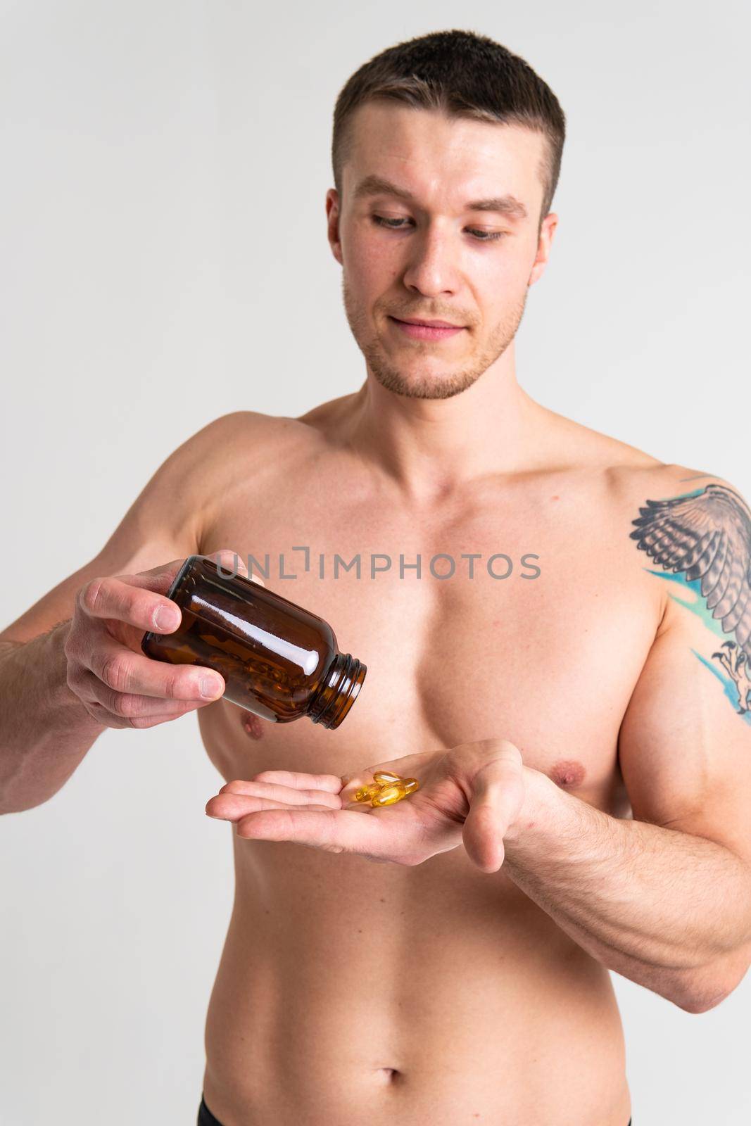 Fish oil is eaten by a man in the hands of vials and a glass bottle fish health vitamin, treatment tablet healthcare lifestyle, gel People smile fat, background female giving dieting by 89167702191