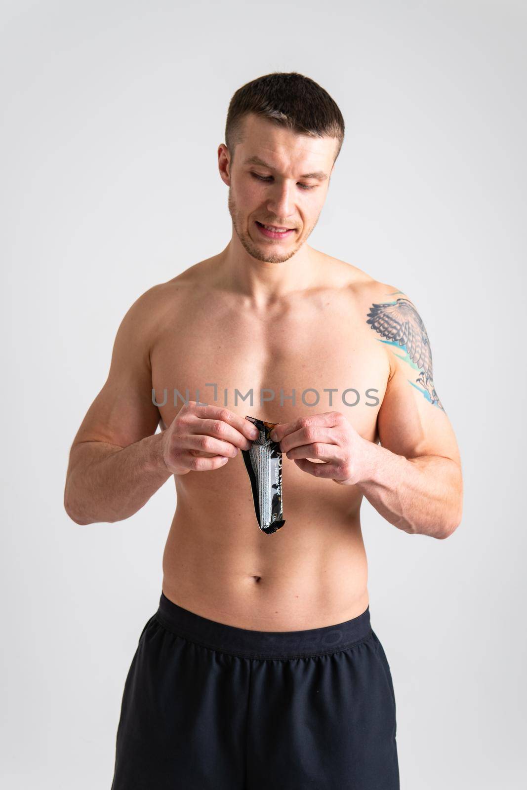 Man eats protein bar on white background isolated protein healthy, eating man sport white person, isolated Sugar adult, cereal female by 89167702191
