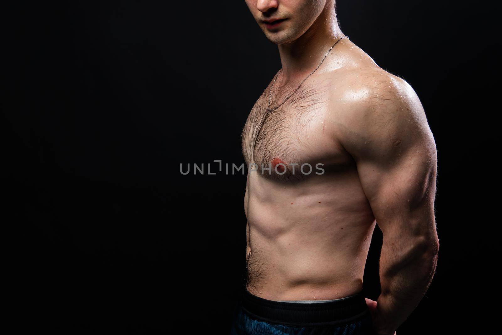 Man on black background keeps dumbbells pumped up in fitness bodybuilding biceps black, arm strong athletic heavy, person weightlifting. power, people fit hands behind your back, press tense beautiful body by 89167702191