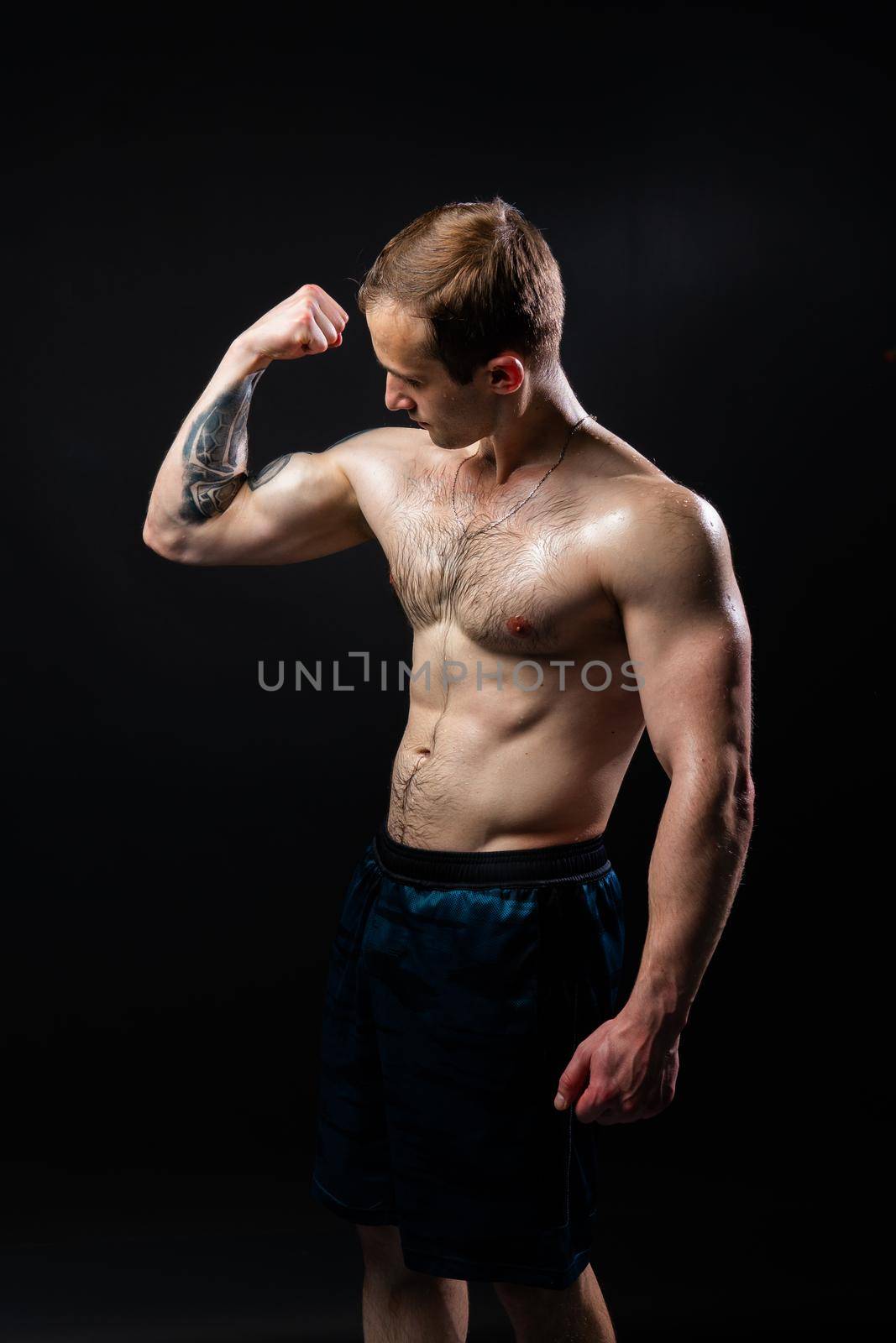 Man on black background keeps dumbbells pumped up in fitness athlete training workout powerful, male Young metal, human fit by 89167702191