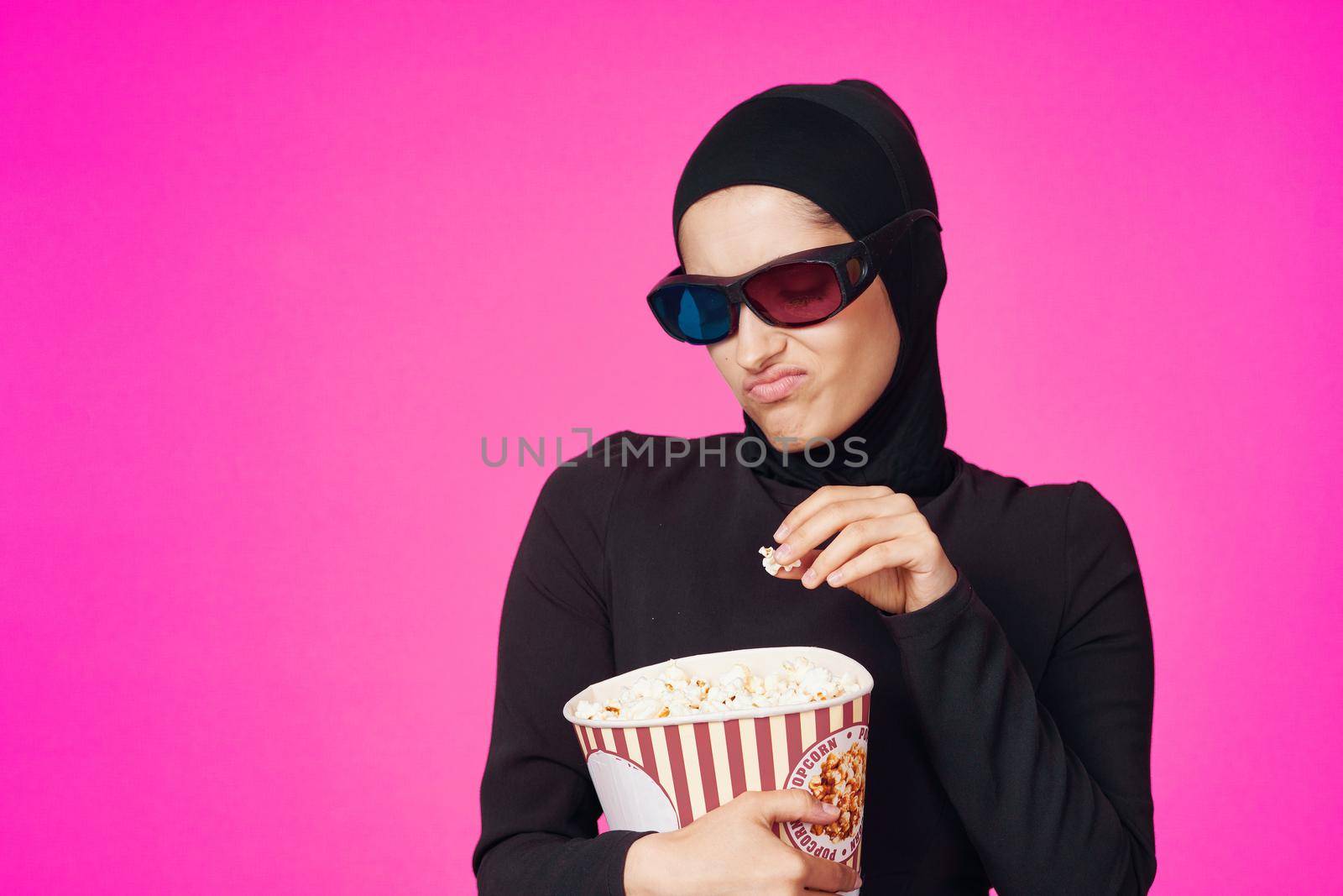 pretty woman in 3D glasses popcorn entertainment movies purple background. High quality photo