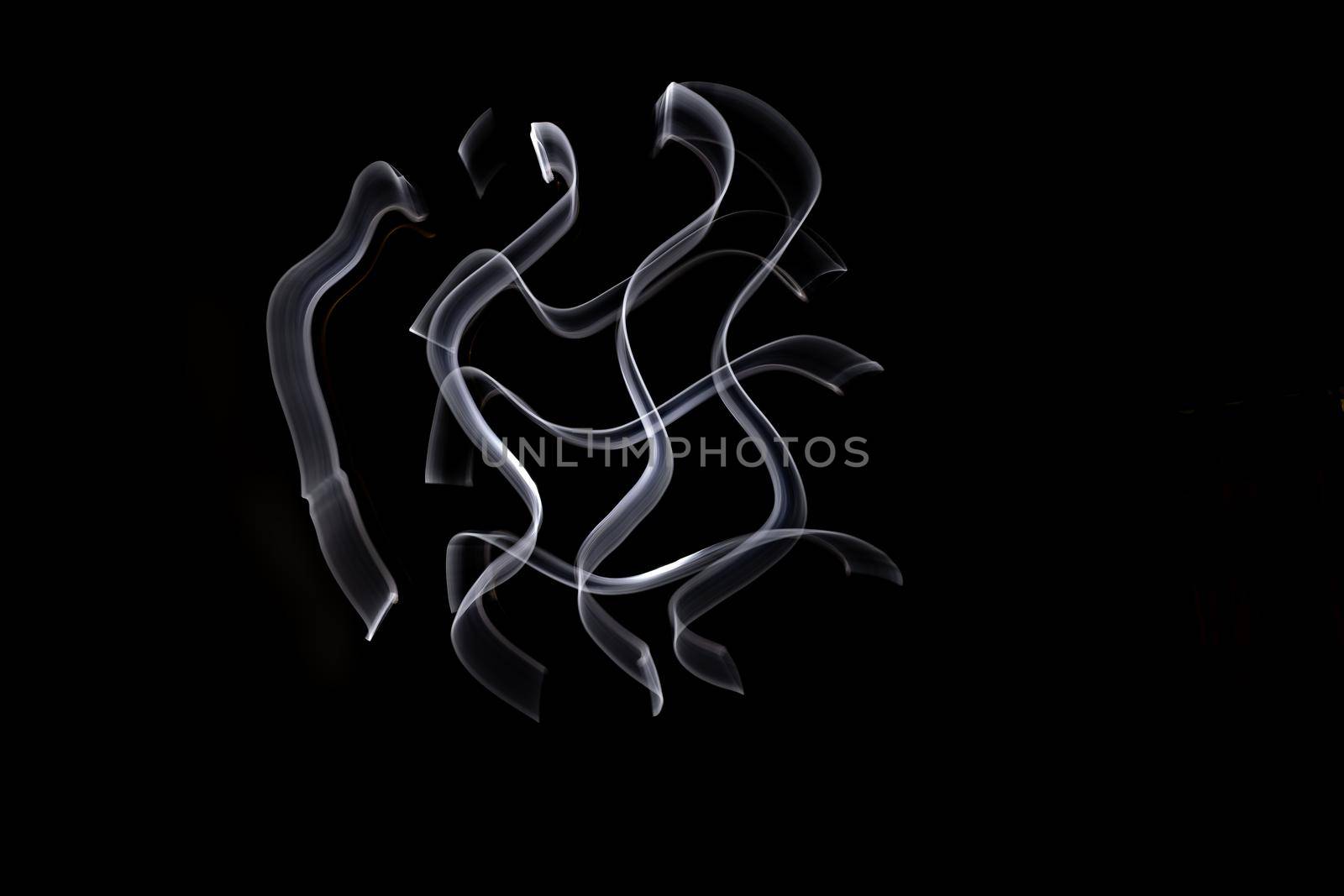 Unique, long exposure, white Led light painting photograph of abstract pattern on black background.