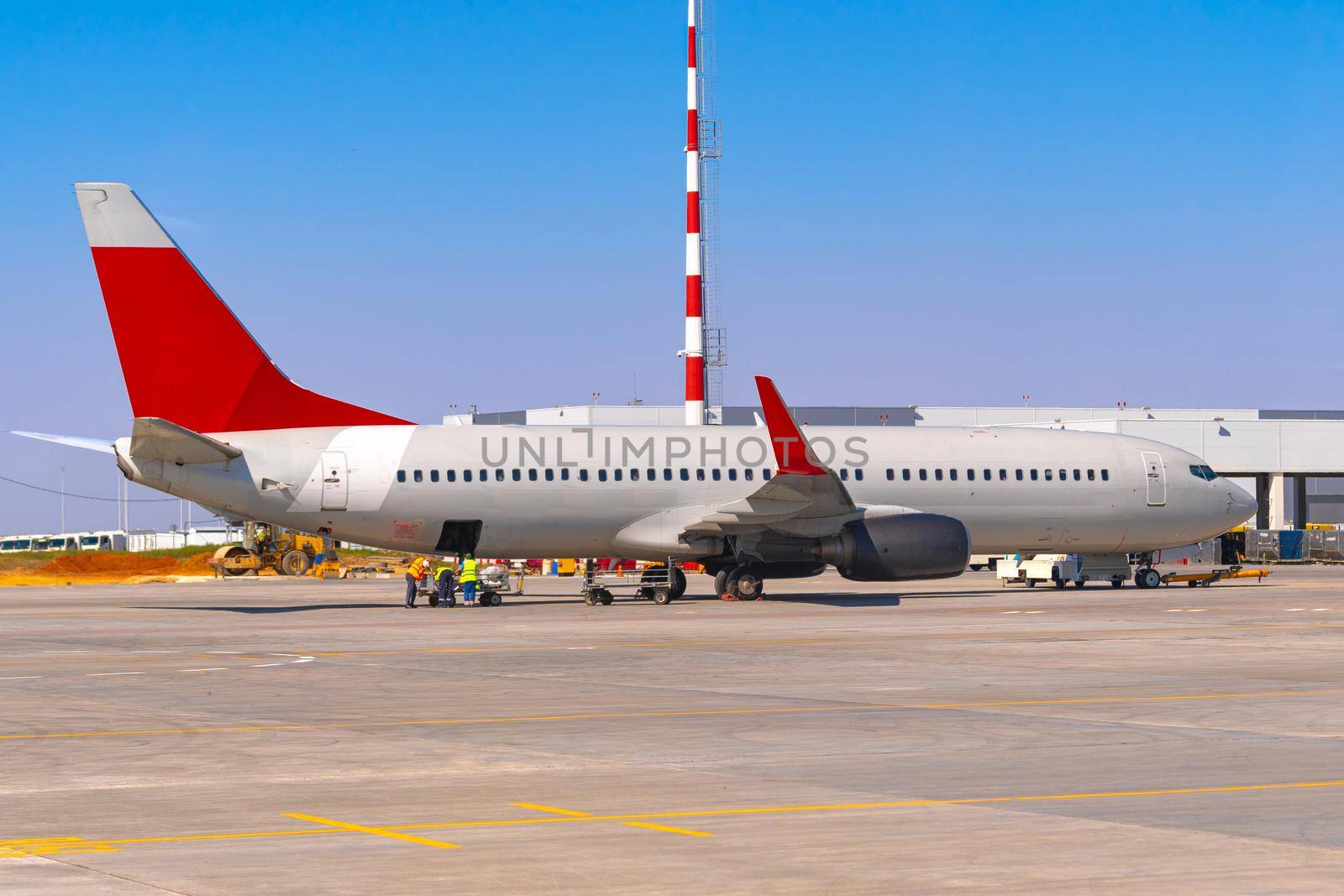 Airplane is parked near gate of airport terminal on sunny day