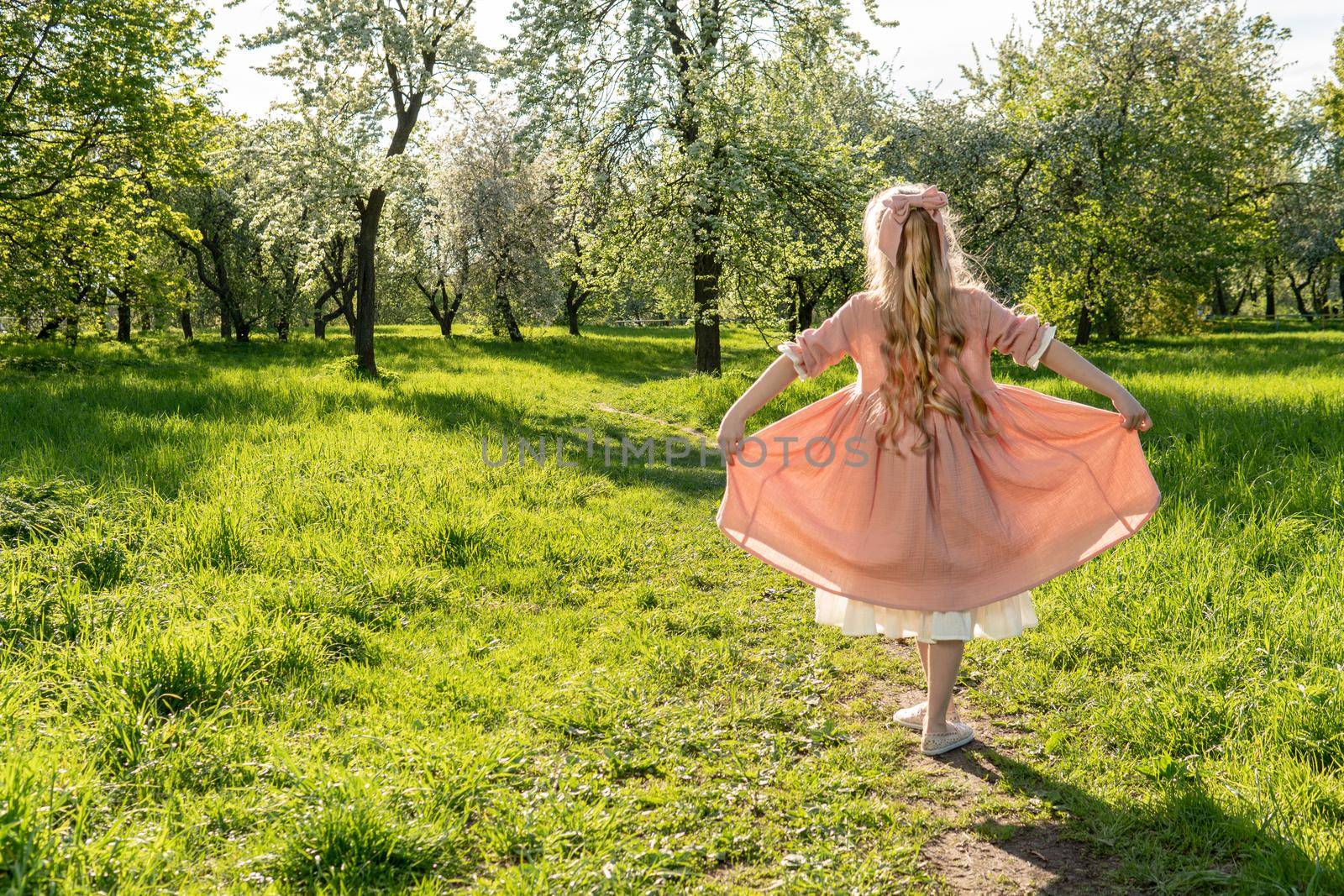 A girl sniffs a beautiful white apple tree, spring in the midst of the flowering of the apple tree is beautiful garden he , outdoor nature beauty dress, female Sexy wellness blossoming woman meadow makeup fresh