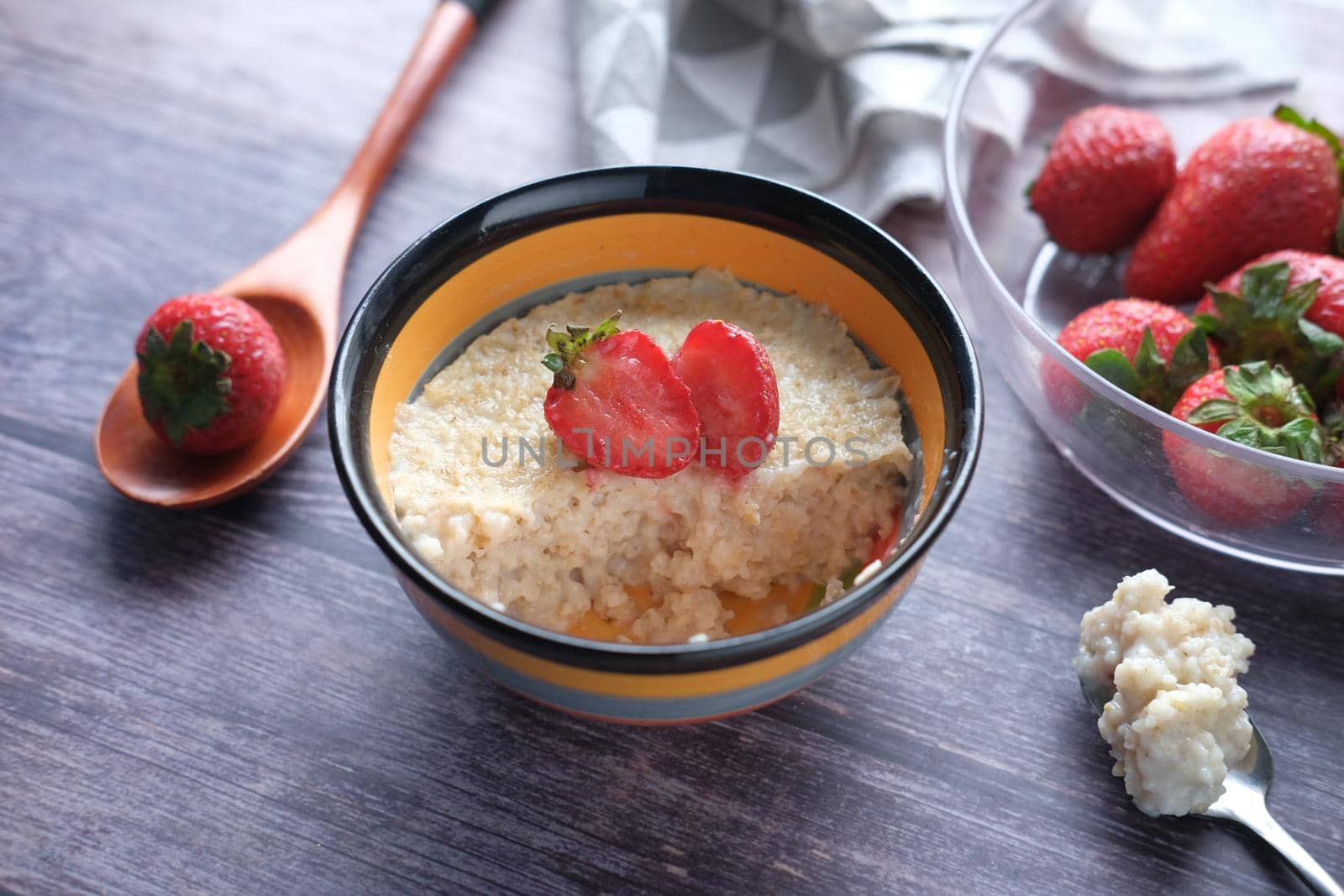 oats flakes and strawberry on wooden table .