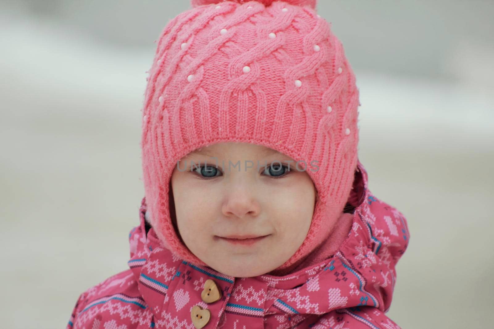 Portrait of a happy little girl having fun on snow, close up