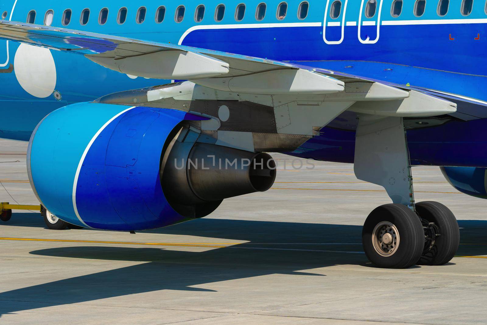 Airplane is parked near gate of airport terminal on sunny day