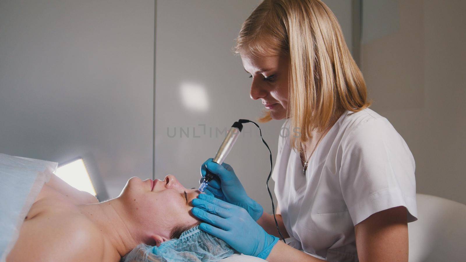 Beautician doing a special massage to her client for facelift, beauty and self-care concept