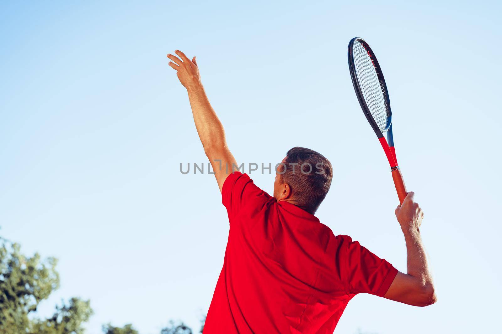 Young proffesional tennis player doing a serve by Fabrikasimf