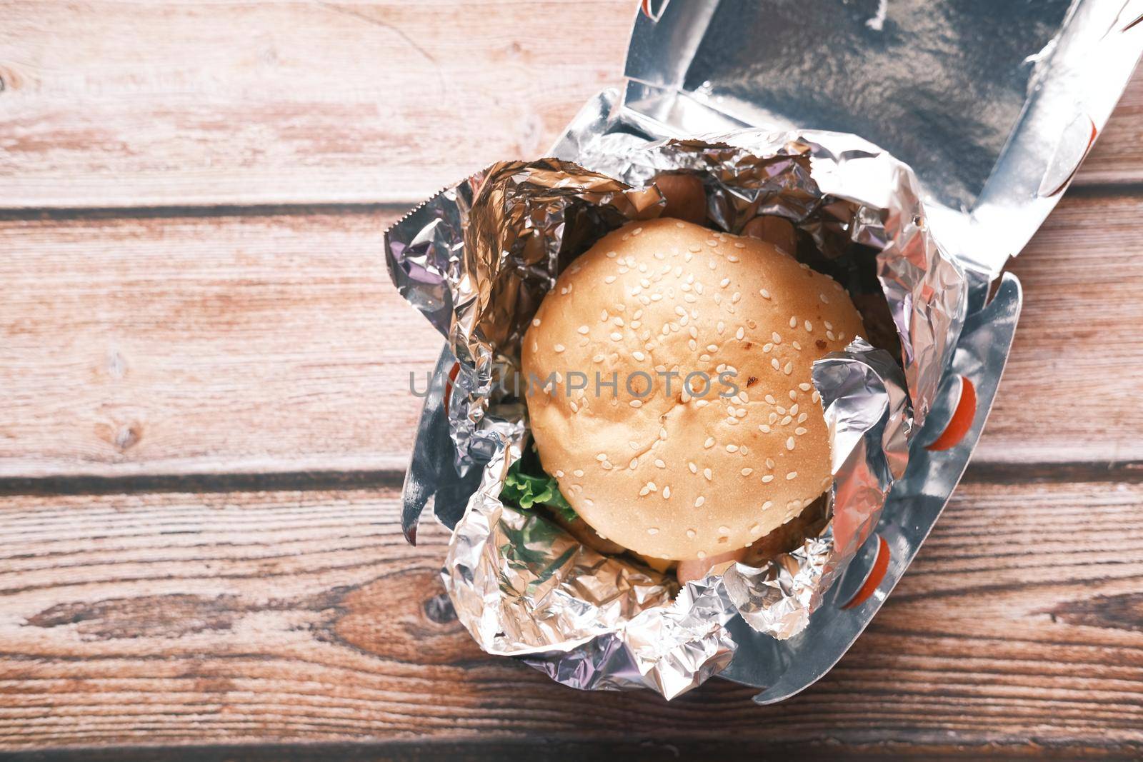 beef burger in a take away box on table .