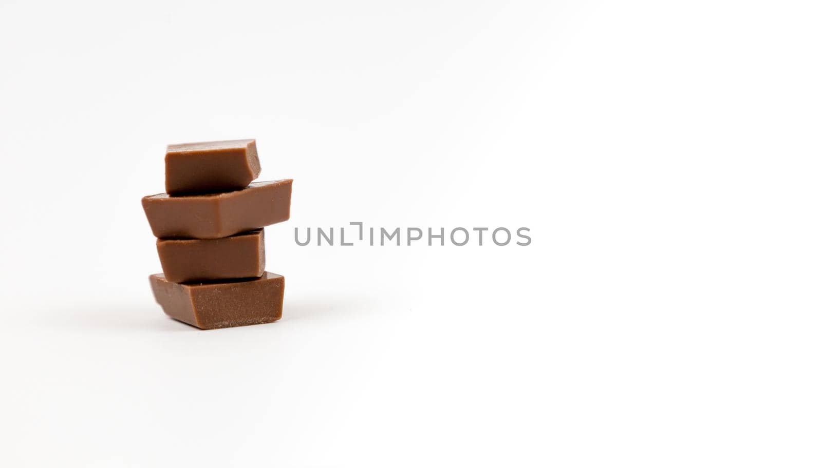 Macro photo of Chocolate bar. Broken pieces over white background.