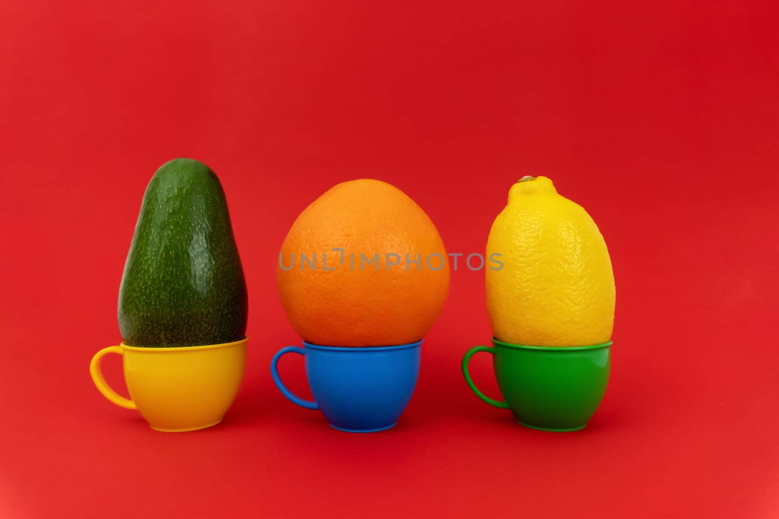 Three cups with fruits on red background by uveita