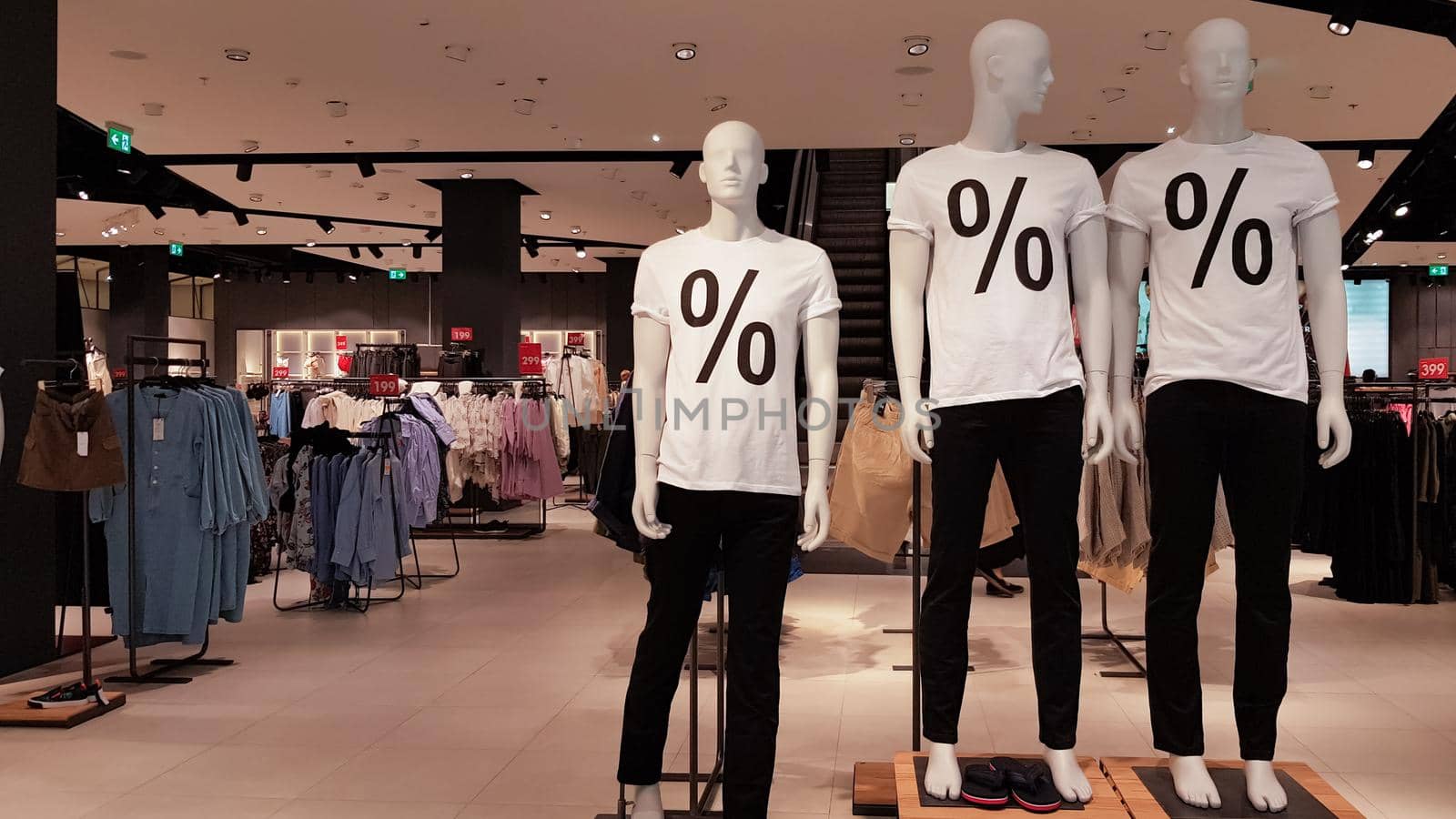 Mannequins wearing white T-shirts with a percent sale sign in a shopping mall Promotion, advertising, shopping and black friday concept. Ukraine, Kiev - September 1, 2020.