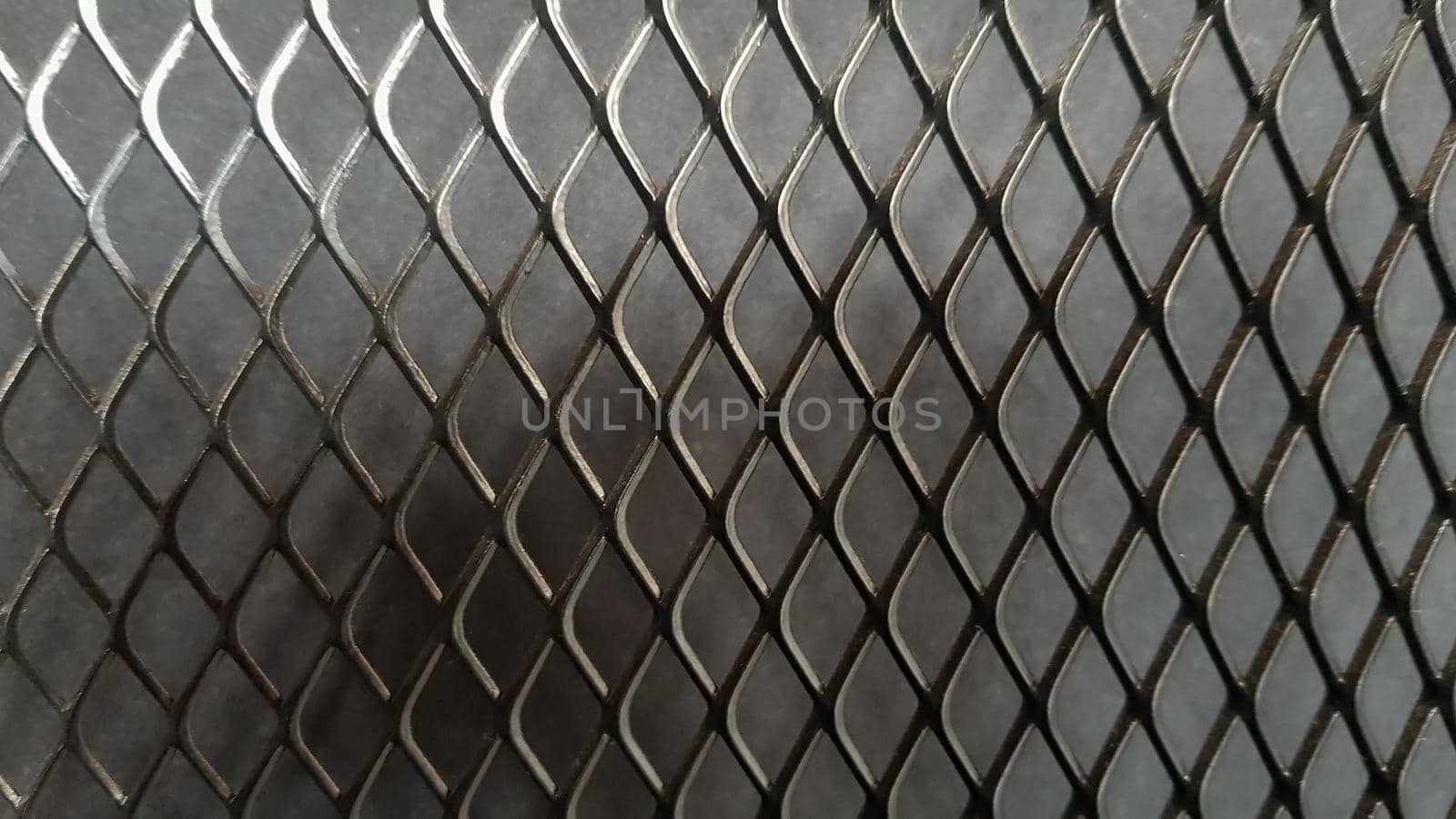Metal mesh seamless pattern. Black metal mesh texture on a black background. Bulletin board for text and message design. Rhombus shape.