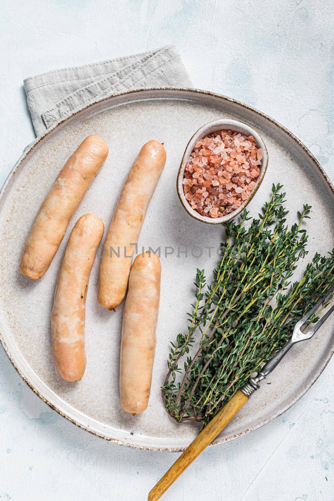 Fried chicken and turkey sausages on a plate. White background. Top view.