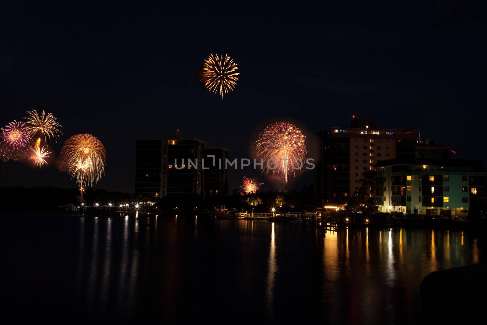 Fireworks over skyline over Hickory Pass leading to the ocean in Bonita Springs, Florida.