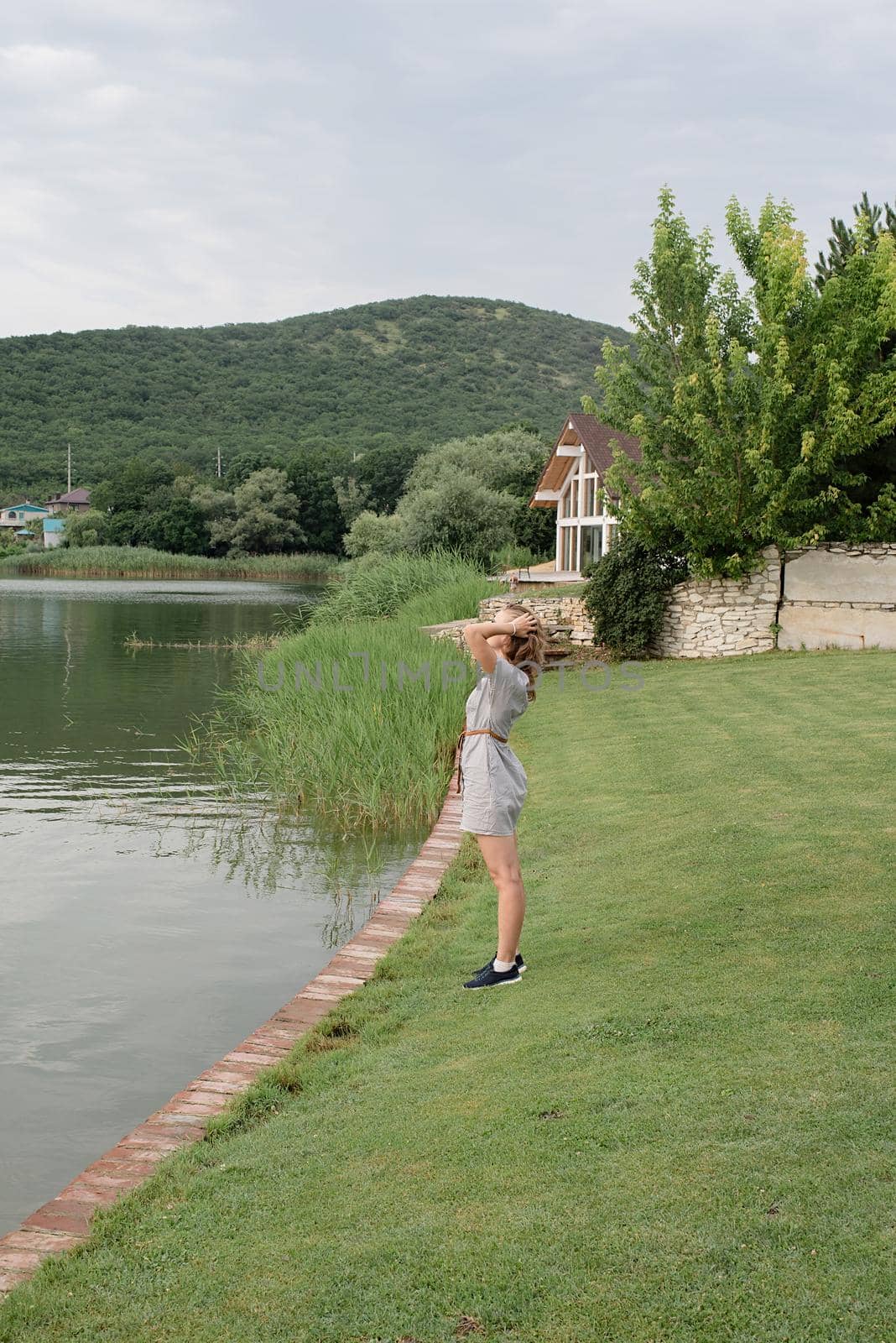 woman standing near the lake, looking away by Desperada