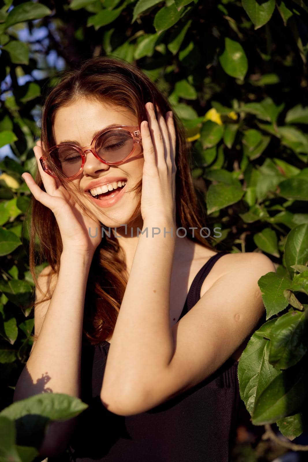 cheerful woman in black swimsuit green leaves nature posing by Vichizh