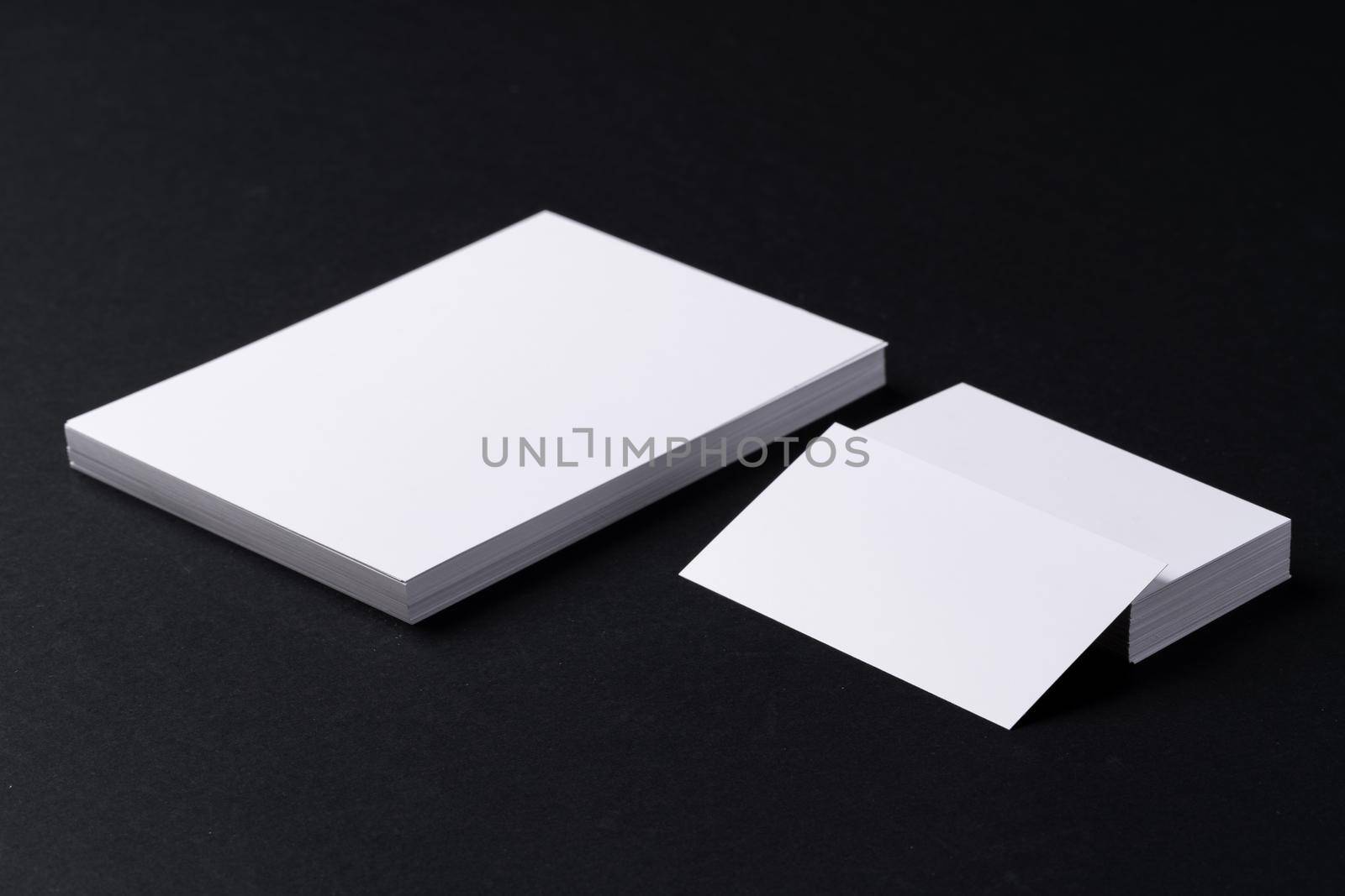 White blank business cards on dark black background by Fabrikasimf